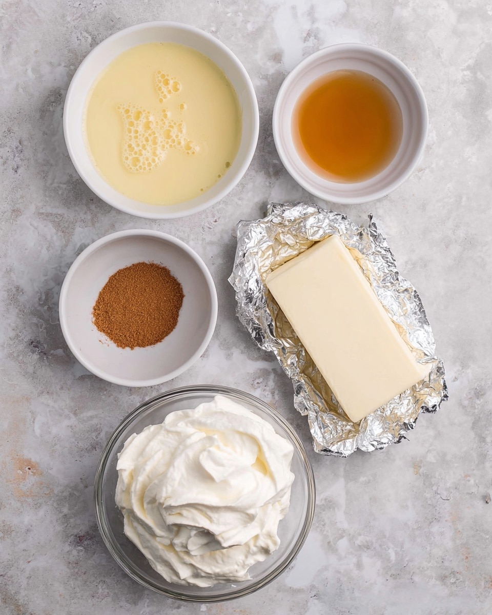 The image shows five small white bowls and a block of cream cheese wrapped in foil placed on a white marbled surface. The top left bowl contains a light yellow liquid with small bubbles on the surface. To its right is a smaller bowl holding a golden brown syrupy liquid. Below these bowls, the block of cream cheese appears smooth and off-white. To the left of the cheese, one bowl has a fine brown powder. At the bottom center, a clear bowl is filled with thick, white whipped cream with visible whipped texture. photo taken with an iphone --ar 4:5 --v 7