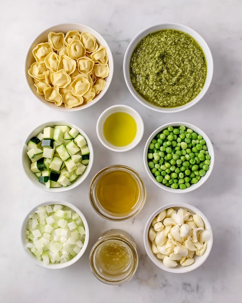 The image shows nine white bowls arranged neatly on a white marbled surface, each containing different ingredients. The top left bowl holds uncooked tortellini pasta, light yellow in color with a folded shape. Next to it, a bowl is filled with green pesto sauce with a rough texture, and to the right is a small bowl containing light yellow olive oil. The middle row features three bowls with diced green zucchini on the left, light green diced celery in the center, and whole green peas on the right. The bottom row has diced white onion on the left, a glass jar with a yellowish broth in the middle, and minced garlic with a light cream color on the right. All bowls are white and the surface is clean with a white marbled texture. photo taken with an iphone --ar 4:5 --v 7