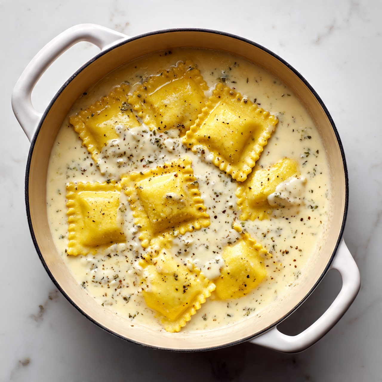 The image shows six square ravioli pieces with yellow pasta dough and crimped edges, partially submerged in a thick, creamy white sauce with visible small curds and black specks, spread evenly across the white interior of a round pot with white handles. The ravioli are arranged loosely in the sauce, some overlapping slightly, with the texture of the filling peeking out from the edges. The pot sits on a white marbled surface. photo taken with an iphone --ar 4:5 --v 7