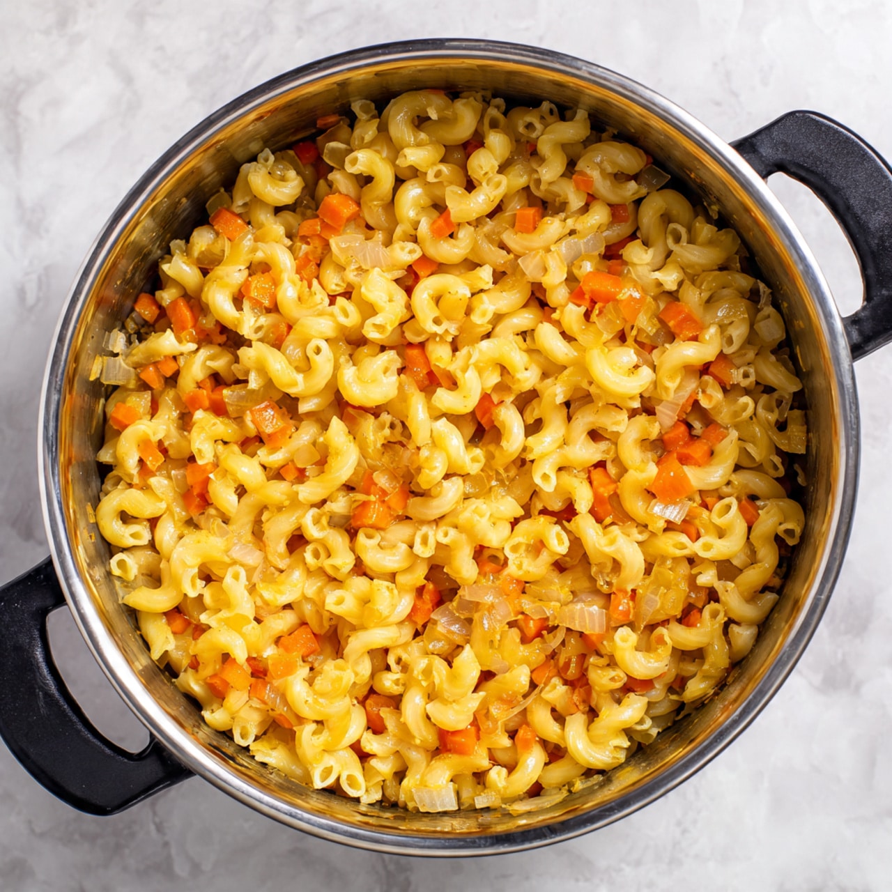A white bowl filled with a mixture of curly elbow macaroni pasta, browned ground meat, and small pieces of cooked onion and red bell pepper. The macaroni is a bright yellow-orange color, while the meat is a darker brown, scattered evenly throughout the pasta. Small green herb sprinkles are lightly spread over the top. A metal spoon sticks out from the right side of the bowl. The bowl sits on a white textured cloth with brown stripes, and the background is a white marbled texture with a second bowl blurred in the distance. Photo taken with an iphone --ar 4:5 --v 7