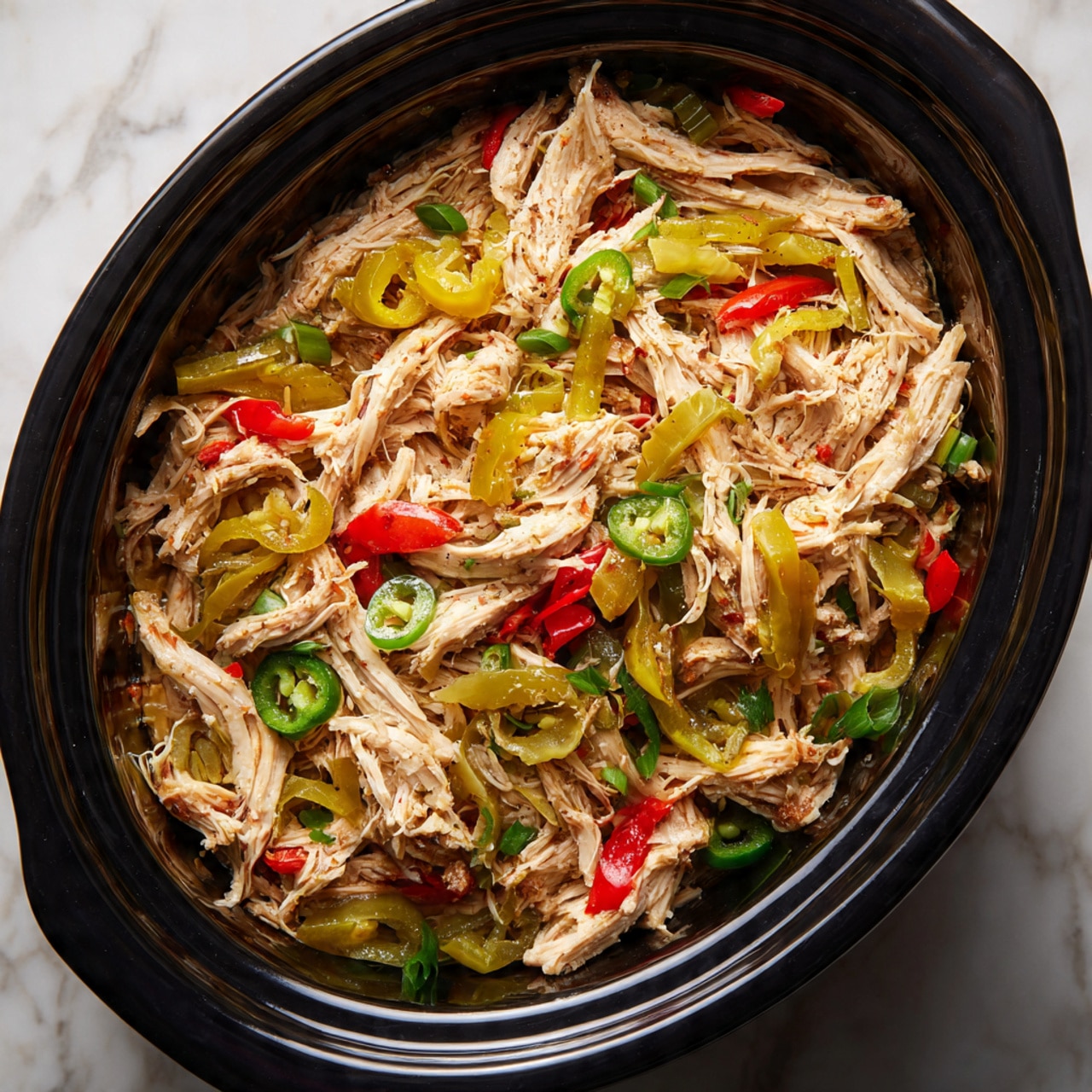The image shows a close-up of four sandwiches placed on a dark patterned metal tray. Each sandwich features a soft, light golden-brown sub roll sliced lengthwise. Inside the sandwich, there are layers of shredded meat mixed with bright orange and light green pickled vegetables scattered throughout. The bottom layer of the sandwich has melted white cheese that peeks out slightly from under the filling. The background is a white marbled surface, and some bits of the filling have fallen onto the tray. photo taken with an iphone --ar 4:5 --v 7