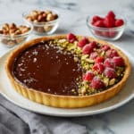 Chocolate Nutella Tart with Hazelnuts, Pistachios, and Raspberries Recipe