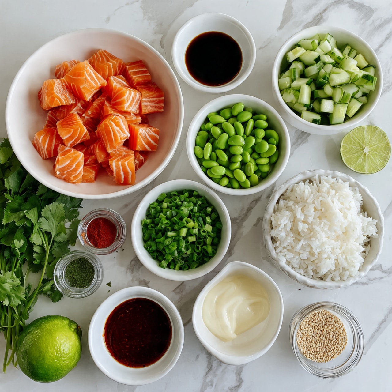 The image shows various ingredients arranged neatly on a white marbled surface. There are nine white bowls and one clear glass container, each holding different items: cubes of fresh salmon with orange and white stripes sit in a large bowl; chopped green cucumbers mixed with sliced green onions fill another; bright green edamame beans fill a small bowl; fluffy white rice occupies a square glass container; a white bowl holds thick white and light yellow sauces or creams; a bowl contains dark red spicy sauce; a small bowl has dark soy sauce; a small bowl contains two powders along with a red sauce on one side; a glass jar of sesame seeds is also included. On the side, a fresh green lime and a bunch of green cilantro are placed, completing the colorful setup. photo taken with an iphone --ar 4:5 --v 7