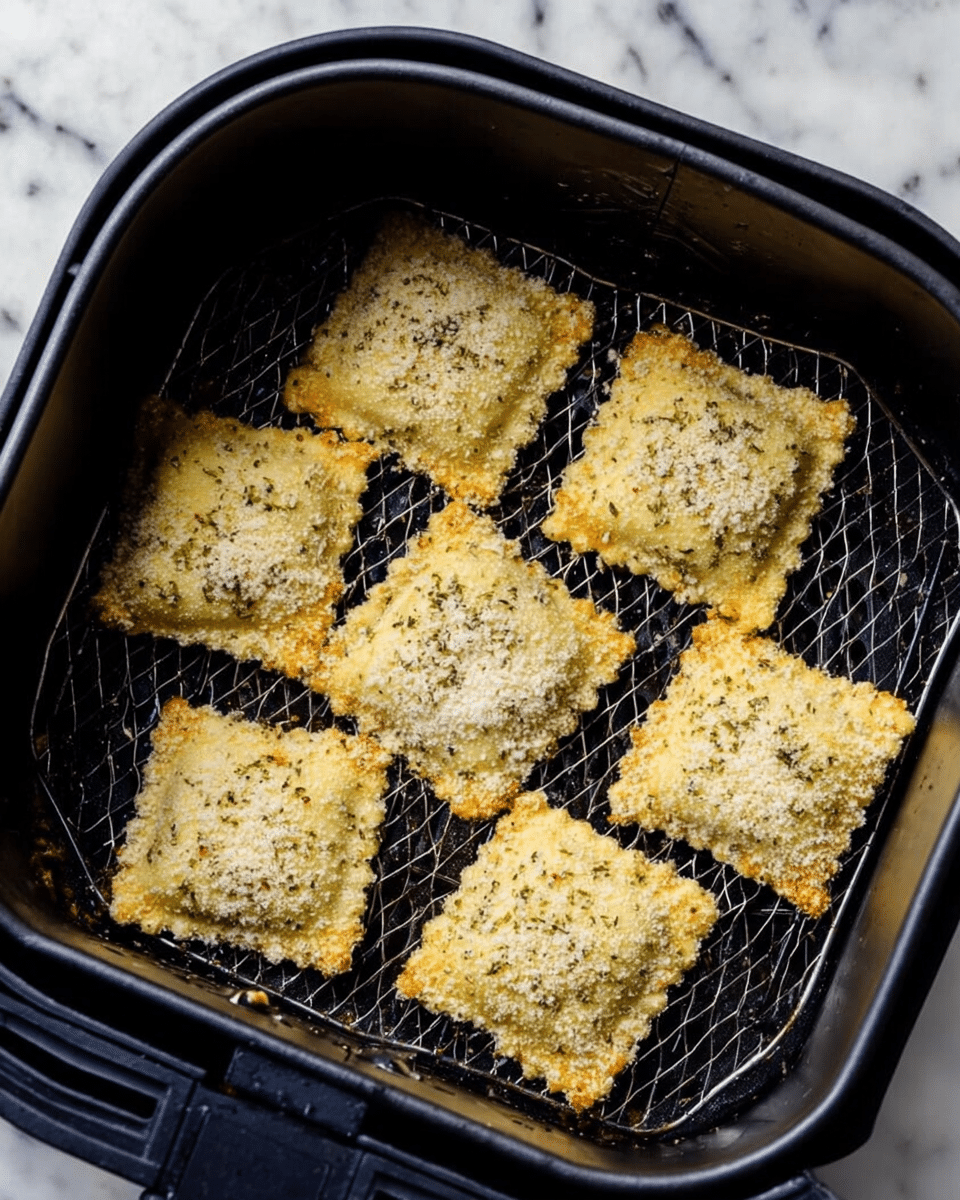 The image shows eight square pieces of breaded food with a light golden-brown crust inside a black air fryer basket. Each piece has a rough, crumbly texture coating with some specks of herbs visible. The pieces are neatly arranged in two rows, evenly spaced so they do not touch each other. The black basket has a mesh base, which creates a pattern under the food. The air fryer itself is black, and the background is a white marbled surface. Photo taken with an iphone --ar 4:5 --v 7