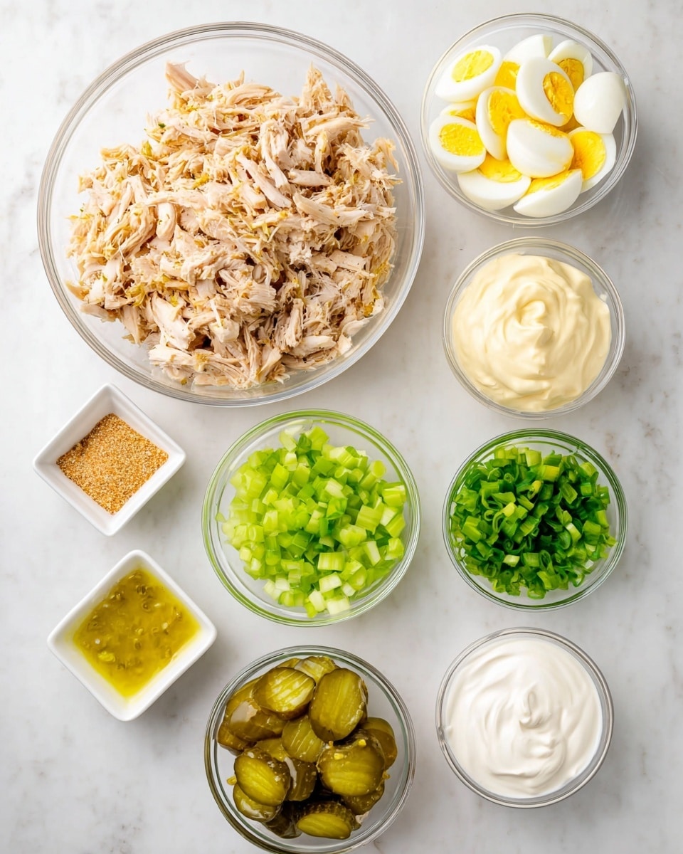 The image shows a white marbled surface with nine small white and clear bowls arranged in a loose circle. At the top center is a large clear bowl filled with shredded cooked chicken, light brown with some darker seasoning bits. To its right is a small clear bowl containing chopped hard-boiled eggs with yellow yolks and white edges. Below that is a small white bowl filled with chopped green celery. To the left of the celery is another small clear bowl with chopped green onions. Below the chopped onions is a tiny white square dish with green relish in a yellowish liquid. To the left is a small white square dish with light tan seasoning powder. Above it is a small white bowl with pale yellow mayonnaise. Above that is a small white bowl with creamy white sour cream. In the center of the circle, a medium-sized clear bowl holds sliced green pickles. The arrangement is neat and colorful, all displayed on the white marbled surface photo taken with an iphone --ar 4:5 --v 7