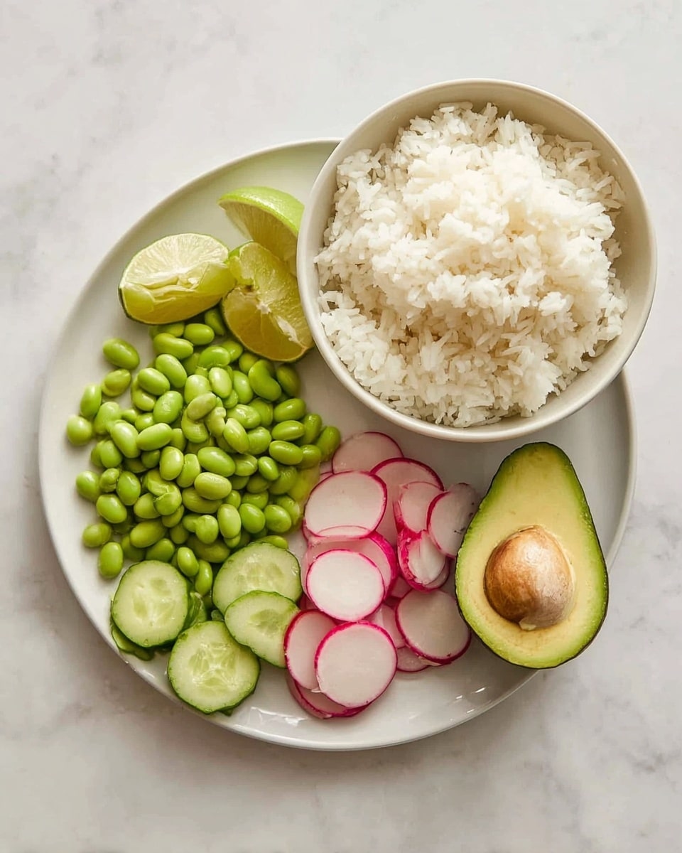 There is one white bowl filled with fluffy white rice on the right side on a white marbled surface. Next to it on the left, there is a white plate with six sections of ingredients: four pale green lime wedges at the top left, bright green shelled edamame beans in the top center, thin round slices of pink and white radish on the right, green cucumber slices on the bottom left, and a halved avocado with smooth light green inside and skin on the bottom right. The ingredients are neatly arranged in rows next to each other. Photo taken with an iphone --ar 4:5 --v 7