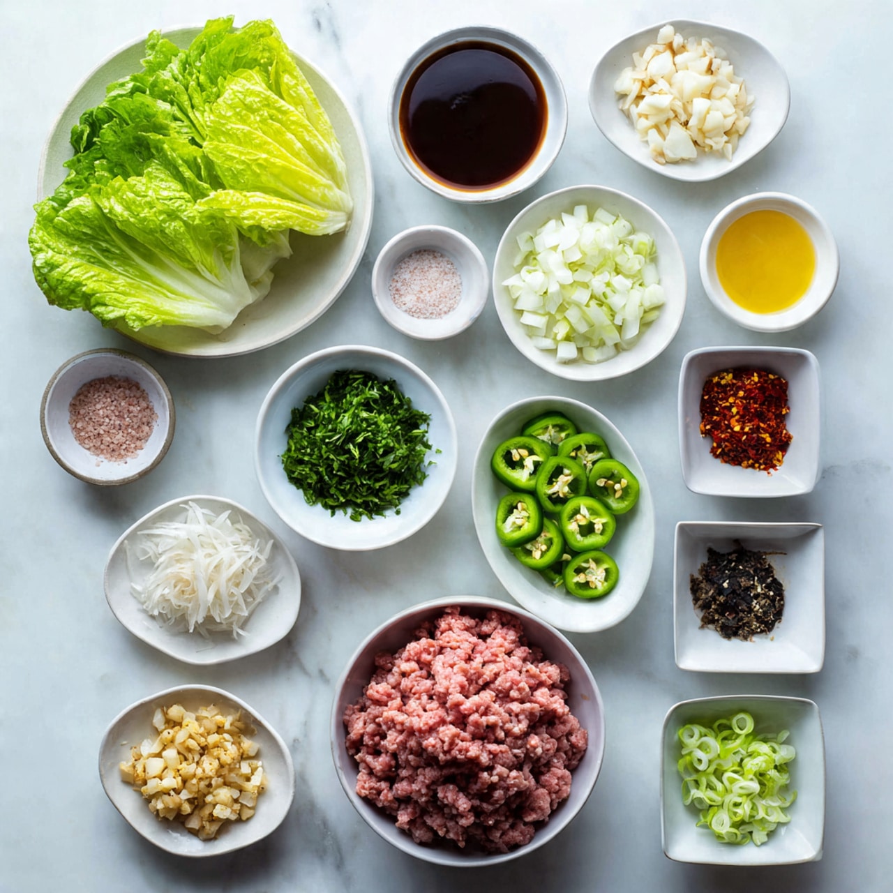 The image shows a white marbled surface with several small white bowls and plates arranged neatly, each holding different ingredients. Starting from the top left, there's a bunch of fresh green lettuce leaves, next to it a small round white bowl with a dark brown sauce. To the right is a small square white bowl with a light yellow liquid. Below, a small round white plate has chopped green herbs. To the bottom right of that is a large round white bowl filled with raw minced pink meat. Below the meat bowl is a small square white bowl with bright green sliced chili peppers. To the left of the chili, a small round plate contains pink salt and black pepper. Above it, a medium oval white bowl holds finely chopped white water chestnuts. Underneath, there is a small round dish with minced garlic and minced yellow ginger. To the left, a small square white bowl is filled with chopped green onions. At the bottom right, there is another small square white bowl containing finely chopped white onions. Above the garlic dish, a small white bowl holds a dark thick sauce, and next to it is a small white bowl with a light amber liquid. The overall colors are bright and fresh with green, pink, white, and brown tones, placed on a clean white marbled surface photo taken with an iphone --ar 4:5 --v 7