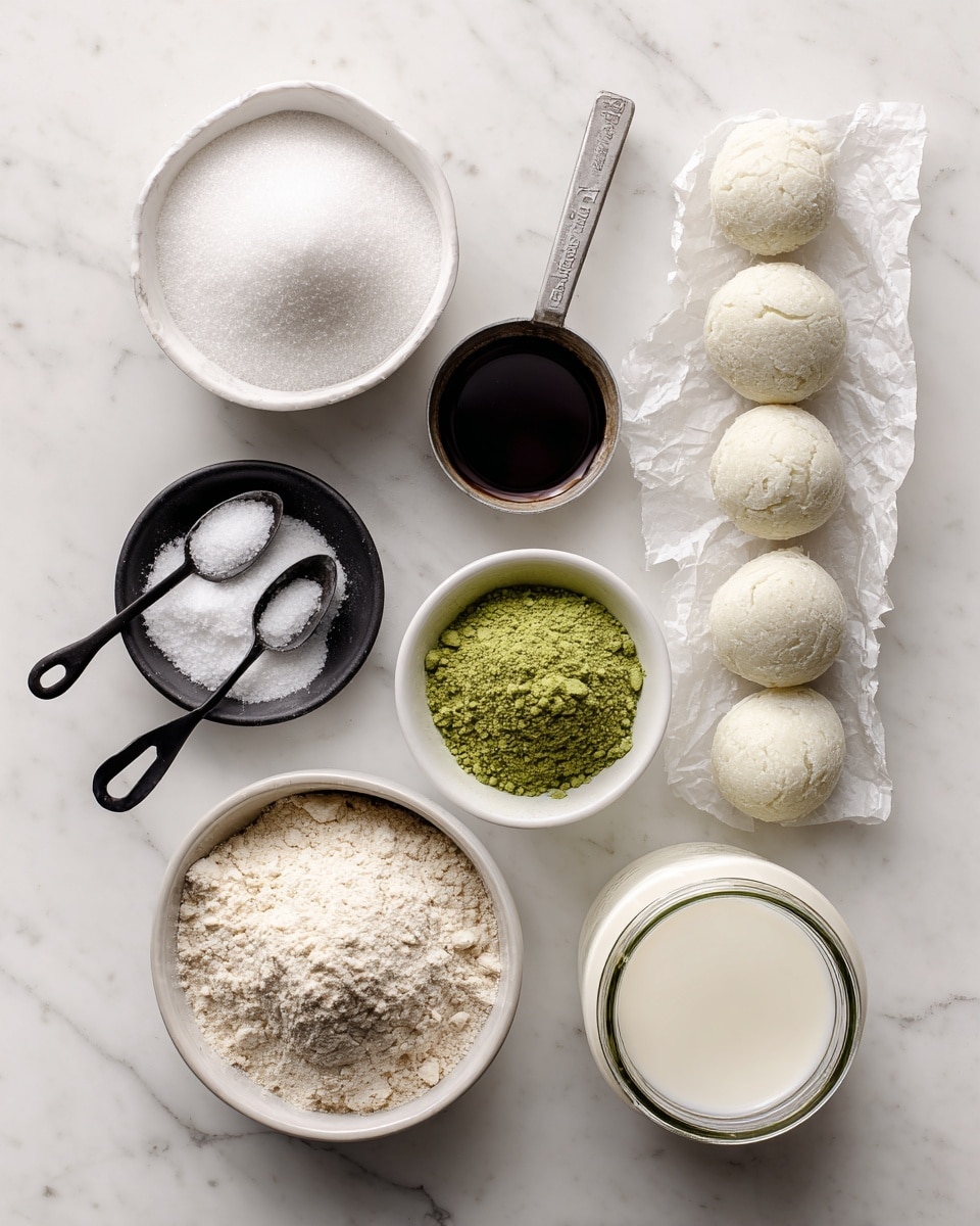 The image shows eight ingredients arranged neatly on a white marbled surface. At the top left, there is a small white bowl filled with white sugar grains, to its right is a silver measuring spoon holding dark brown vanilla extract. On the far right, there are seven round scoops of frozen white coconut oil placed on a crumpled piece of white paper. Below the sugar, black measuring spoons hold small amounts of white salt and white baking powder, each in separate black and white bowls. In the center, a small white bowl contains bright green matcha green tea powder with a fine texture. At the bottom left, a larger white bowl is filled with light beige whole grain flour, and to its right, there is a glass jar filled with creamy white non-dairy milk. All the items are evenly spaced, with clear text labels next to each ingredient. The photo taken with an iphone --ar 4:5 --v 7
