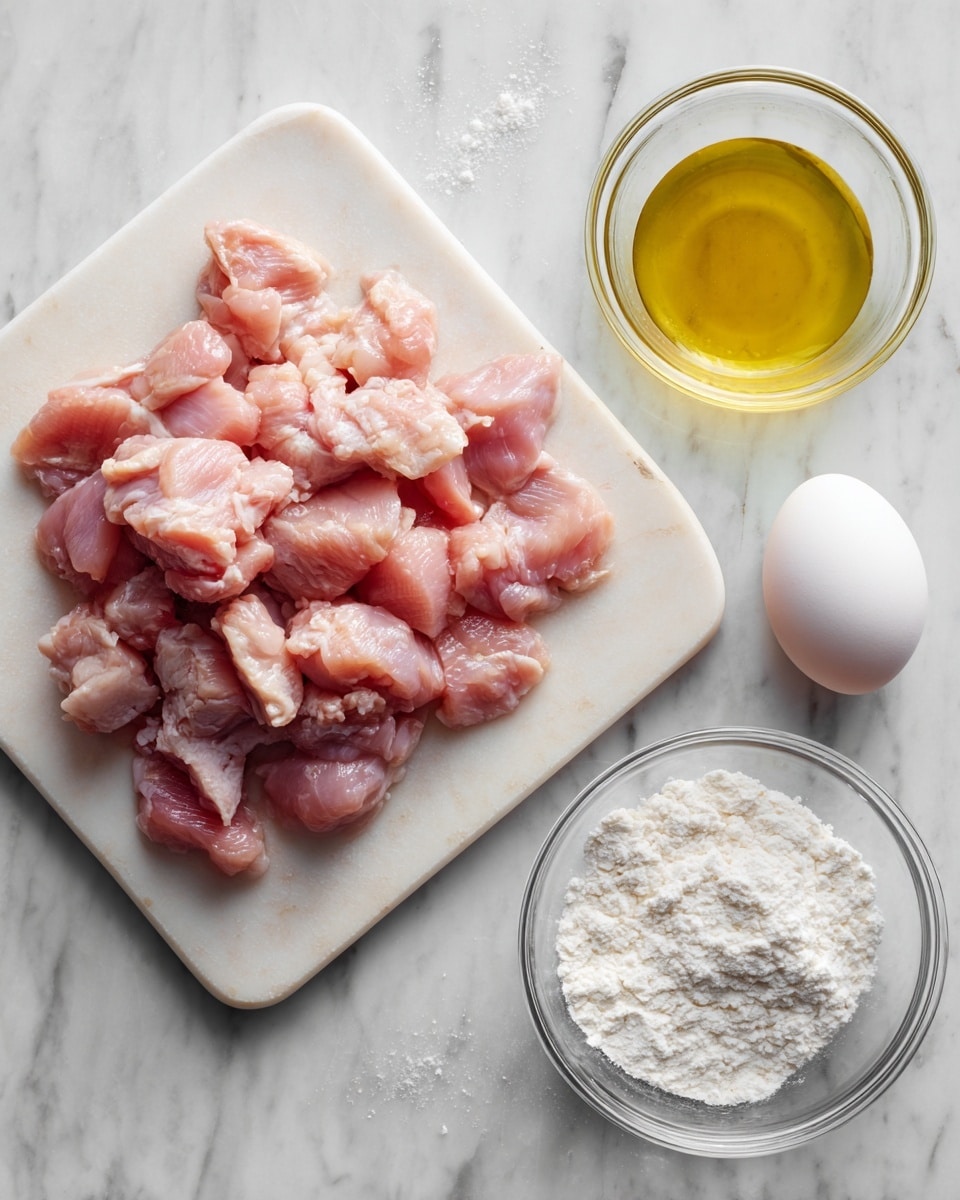 A white cutting board sits on a white marbled surface, filled with many small, pinkish raw chicken pieces arranged in a loose pile. To the right, a clear glass bowl holds light yellow oil, placed on the white marbled background. Below the chicken, there is a small clear glass bowl filled with white cornstarch powder. Near the oil and cornstarch, another small clear glass bowl contains one whole white egg. All items are spaced out on the white marbled surface. Photo taken with an iphone --ar 4:5 --v 7
