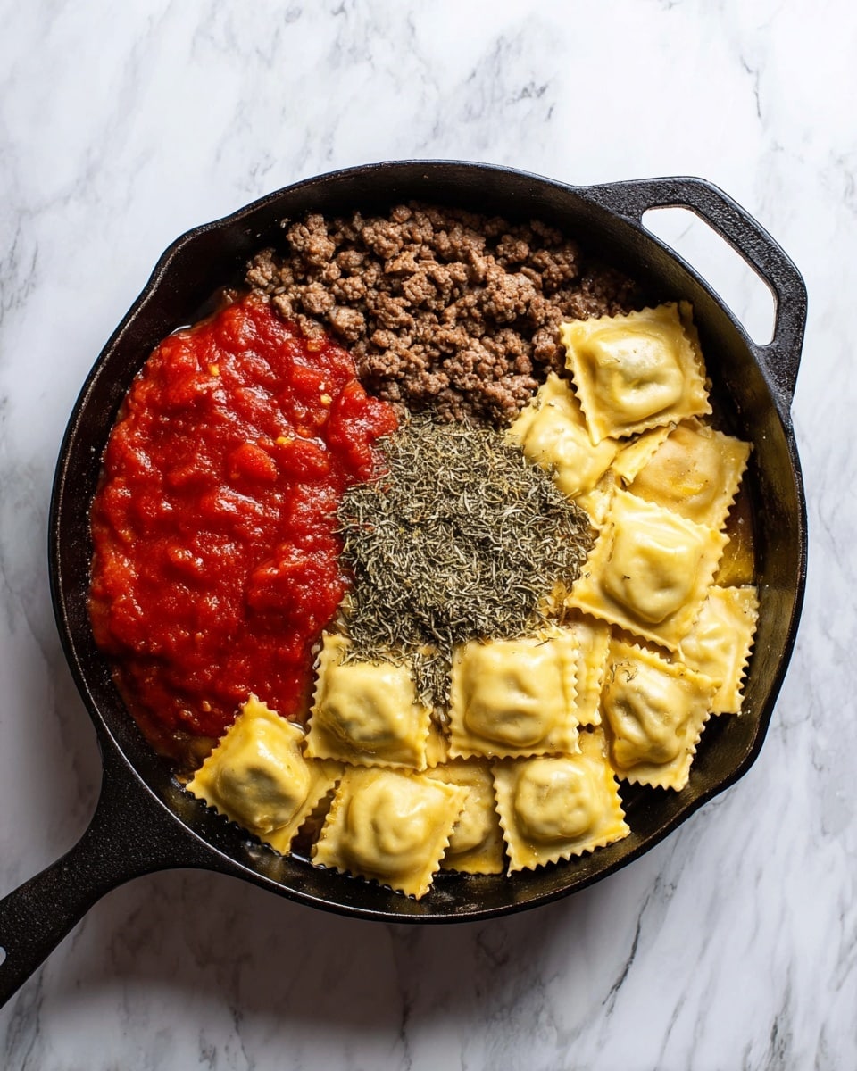 In a black cast iron pan on a white marbled surface, there is a mix of ingredients in separate sections forming layers. One section shows cooked brown ground meat with a slightly oily texture. Next to it is a bright red tomato sauce with a thick and smooth texture. Overlapping the sauce is a layer of dry dried herbs in greenish-gray color, unevenly spread. The largest section is filled with multiple square-shaped ravioli pasta pieces in pale yellow, slightly firm with a soft sheen, arranged loosely and mostly lying flat. The layers and colors create a clear, separated look within the pan. Photo taken with an iphone --ar 4:5 --v 7