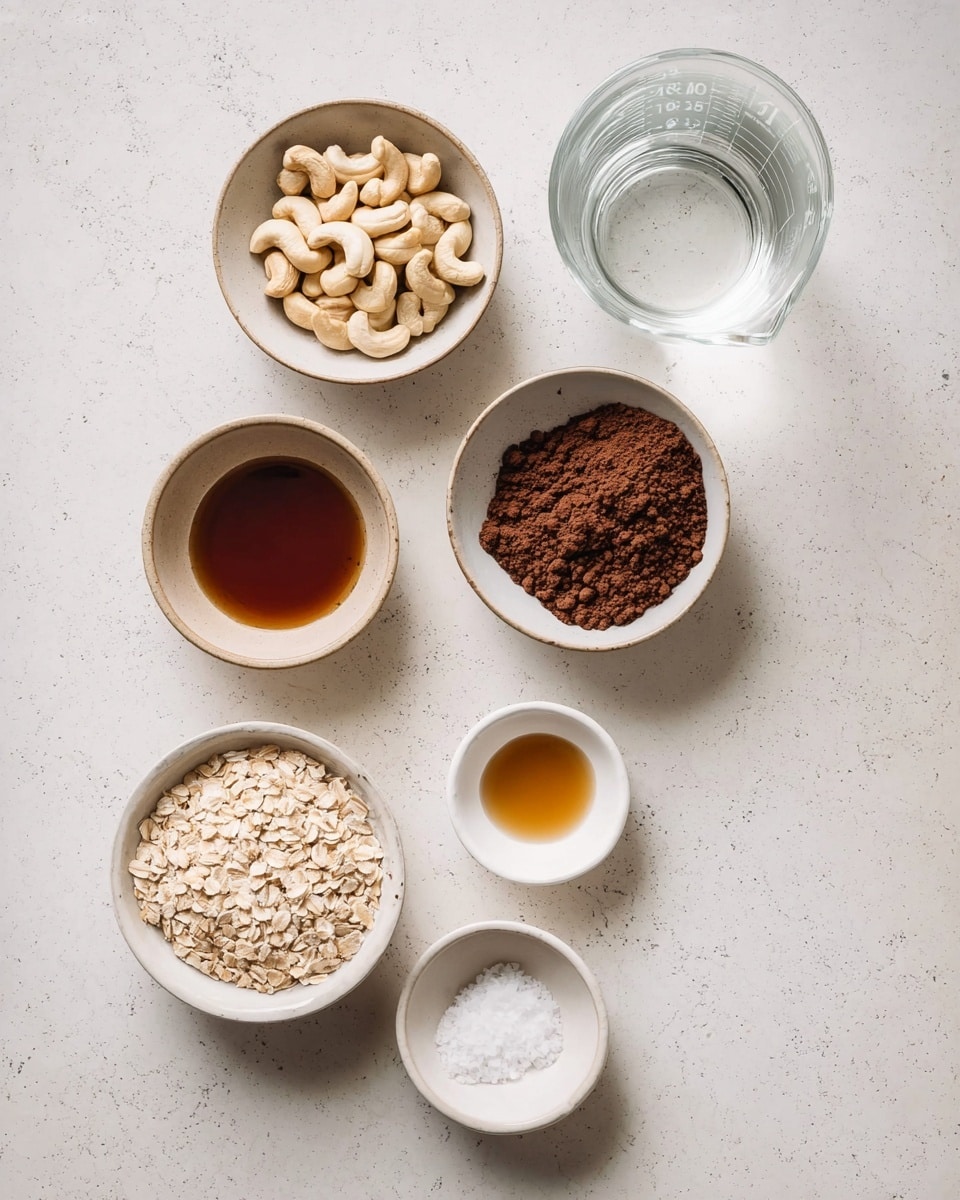 The image shows seven small bowls and a clear measuring cup with water arranged on a white marbled surface. The bowls contain different ingredients: at the top right, a bowl with light beige cashews; below it, a bowl with dark brown cocoa powder with a rough texture; below that, a bowl with light tan oats, flat and dry; at the bottom left, a bowl with white solid coconut oil that has a soft, creamy texture; at the top left, a bowl with dark amber maple syrup, smooth and shiny; next to the bowl with oats, a small white bowl with fine white salt crystals; and at the middle right, a small white bowl with a small amount of dark golden vanilla extract. The clear measuring cup is filled with clear water, sitting at the top right of the bowls. The layout is neat, with the bowls and cup spaced evenly. photo taken with an iphone --ar 4:5 --v 7