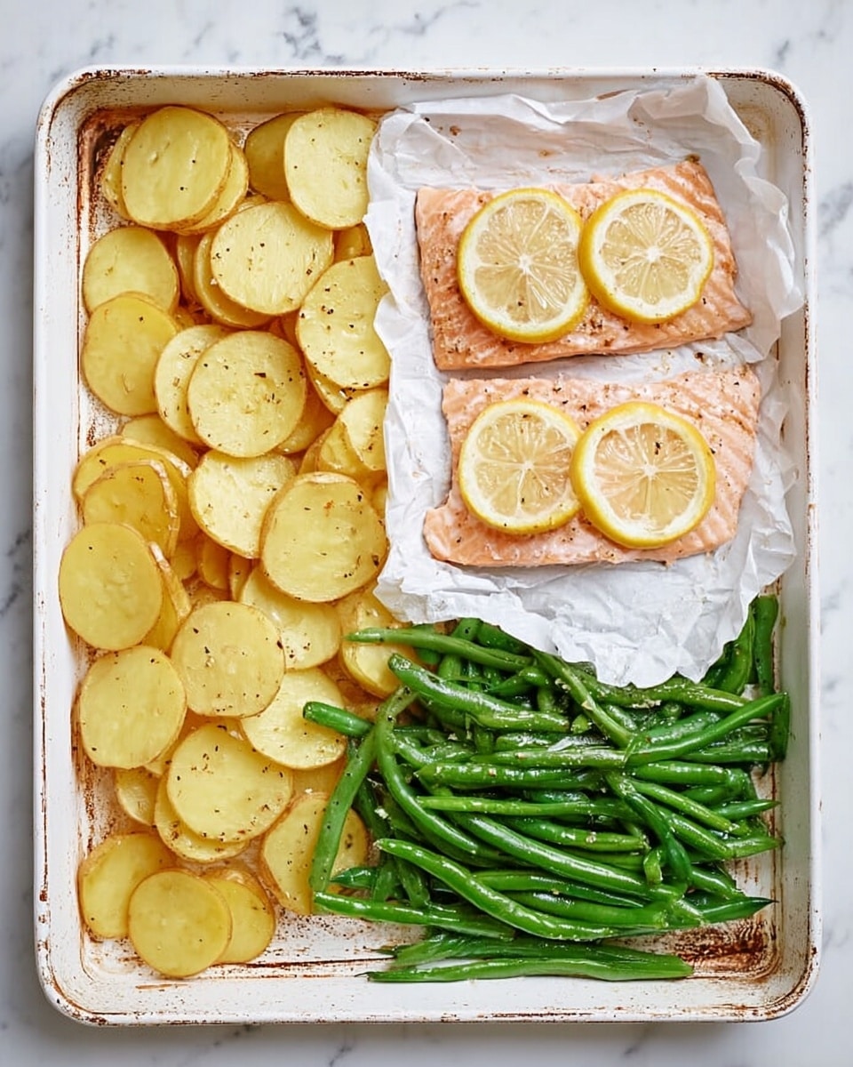 In a white baking tray on a white marbled surface, there are three distinct sections: on the left, a layer of thin, round, golden-yellow potato slices slightly overlapping each other; on the top right, two pieces of pink salmon fillets topped with three slices of bright yellow lemon, all resting on crumpled white parchment paper; and on the bottom right, a pile of fresh, bright green green beans with a slight sheen and sprinkled with small seasonings. The tray’s edges show some light brown baking marks. photo taken with an iphone --ar 4:5 --v 7