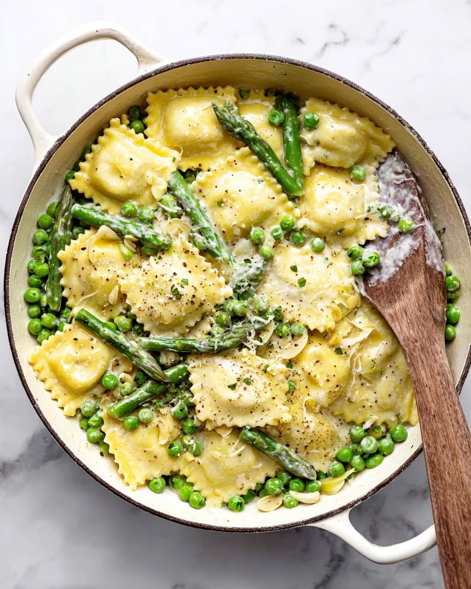 A white pan filled with around three layers of food: the first layer shows a light creamy sauce with specks of black pepper; the second layer includes bright yellow ravioli pieces with ruffled edges evenly placed throughout; the third layer has fresh green peas scattered across and some whole green asparagus spears spread among the ravioli, along with thin slices of light-colored garlic on top. A wooden spatula with some creamy sauce is resting inside the pan on the right side. The pan sits on a white marbled surface. Photo taken with an iphone --ar 4:5 --v 7