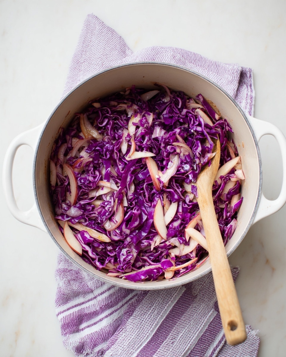 A round white pot with two handles holds a mix of thin purple cabbage strips layered with light pinkish slices that look like apple and some translucent white onion strips, showing a mix of rich purple, pale pink, and soft white colors. A wooden spoon with a light textured handle rests inside the pot on the right side, partly touching the food. The pot sits on a white marbled surface with a folded purple and white striped cloth beneath it on the upper side of the image. The colors and textures inside the pot show fresh, thinly sliced vegetables with a soft, moist look, and the scene is bright and clear. photo taken with an iphone --ar 4:5 --v 7