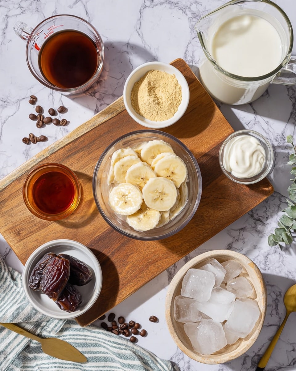 The image shows a top-down view of various ingredients arranged on a wooden cutting board and a white marbled surface. Centered is a glass bowl with frozen banana slices, light yellow with frosty texture. Around it are small white bowls holding different ingredients: one with light yellow powder, one with honey-colored liquid, and one with creamy white yogurt. A measuring glass contains a dark brown liquid, likely coffee. Nearby, two dark brown dates lie in a small white bowl. A beige bowl filled with ice cubes rests on the white marbled surface next to a striped cloth. A clear glass pitcher holds light cream-colored milk, with coffee beans scattered nearby. A gold spoon lies at the bottom edge. The setting is bright and clean, with a contrast between the natural wooden board and the white marbled background. Photo taken with an iphone --ar 4:5 --v 7