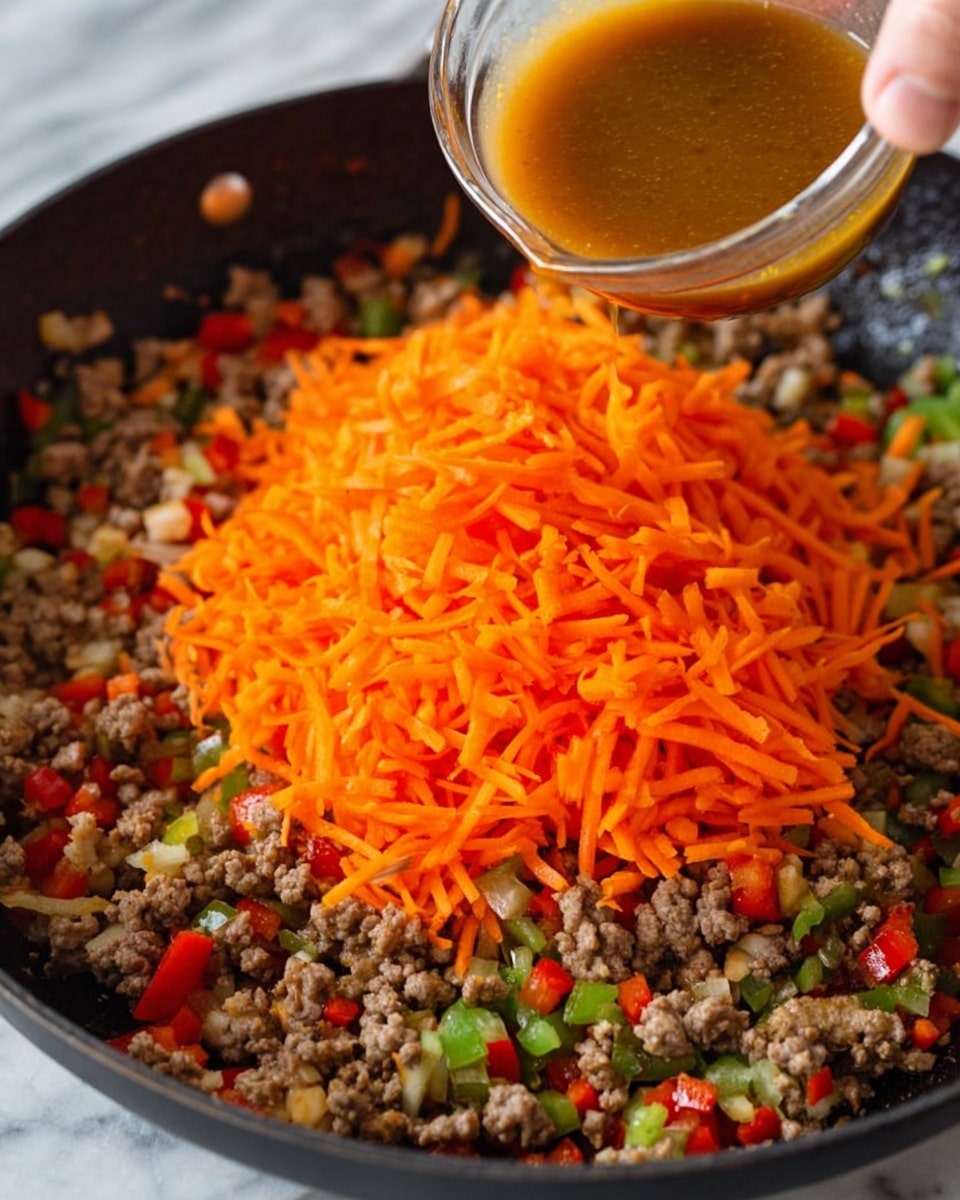 A close-up image shows a black pan on a white marbled surface, filled with a mix of cooked ground meat, small red bell pepper pieces, and some green vegetable bits as the bottom layer, with a large pile of bright orange shredded carrots centered on top. A woman's hand is holding a small transparent bowl with brown sauce, pouring it over the carrots and meat mixture. The overall scene looks fresh and lively with the colors contrasting well. photo taken with an iphone --ar 4:5 --v 7