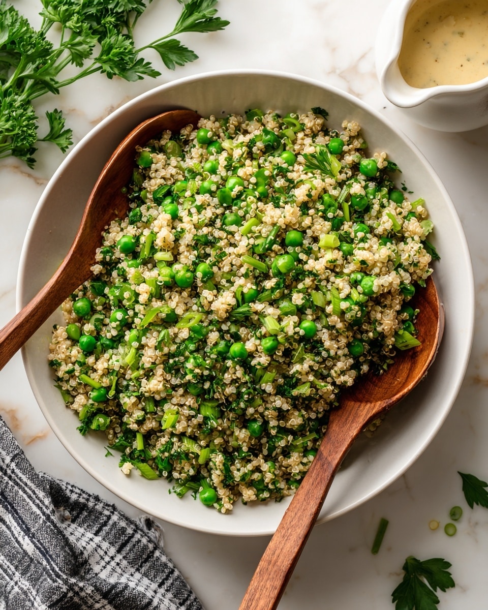 A white bowl filled with a mix of tiny round quinoa grains and bright green peas, scattered with small pieces of chopped green herbs and light green sliced scallions, giving a fresh and textured look. Two wooden spoons rest inside the bowl, one positioned at the left side and the other on top right side, partially submerged in the quinoa salad. Around the bowl, there is a piece of black and white checked cloth on the left and some green parsley leaves scattered on a white marbled surface. At the top right corner, a white pitcher with a creamy yellow dressing sits partly in the frame. Photo taken with an iphone --ar 4:5 --v 7
