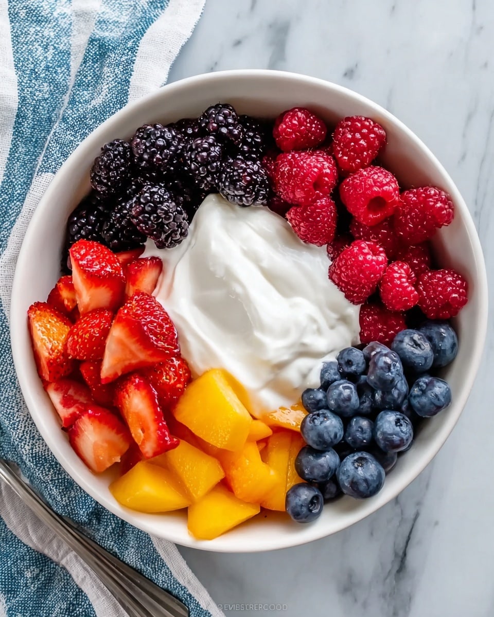 A white bowl full of fresh fruit is on top of a white marbled surface, with a blue and white striped cloth nearby. The bowl shows layers of colorful fruit neatly placed side by side: dark blackberries are on the left, bright red raspberries at the top, dark blueberries to the right, juicy red strawberries on the bottom left, and orange-yellow peach chunks on the bottom right. In the center of the bowl, a smooth, creamy white yogurt sits on top of the fruit, adding softness to the bright colors around it. photo taken with an iphone --ar 4:5 --v 7