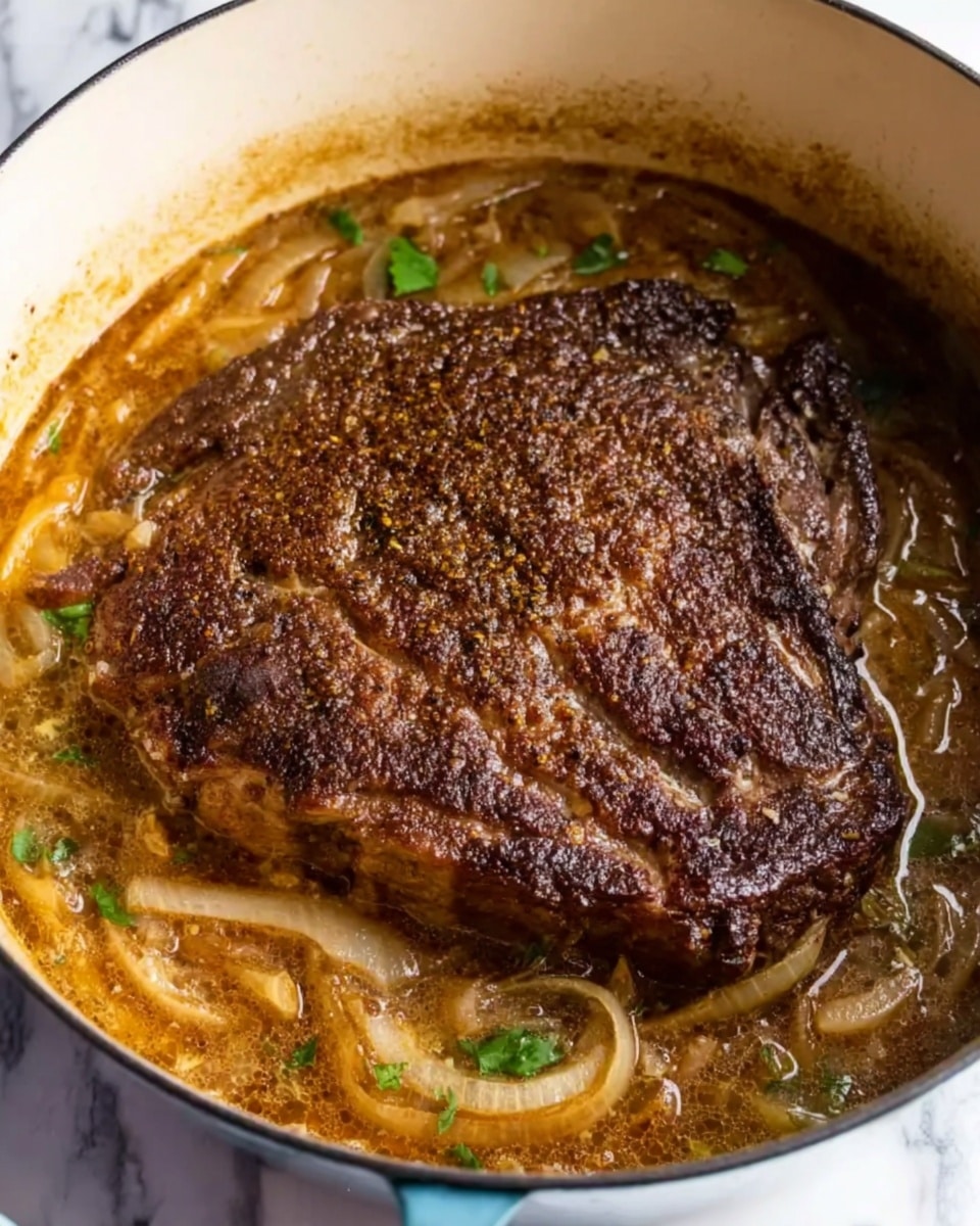The image shows a single large piece of cooked meat with a dark brown, coarse-textured crust on top of a thick, light brown sauce with visible onions and some green herbs, all inside a white pot. The sauce looks rich and bubbling around the meat, with the onions soft and translucent, layering the bottom of the pot while the meat sits in the center, taking up most of the space. The background is a white marbled surface. photo taken with an iphone --ar 4:5 --v 7