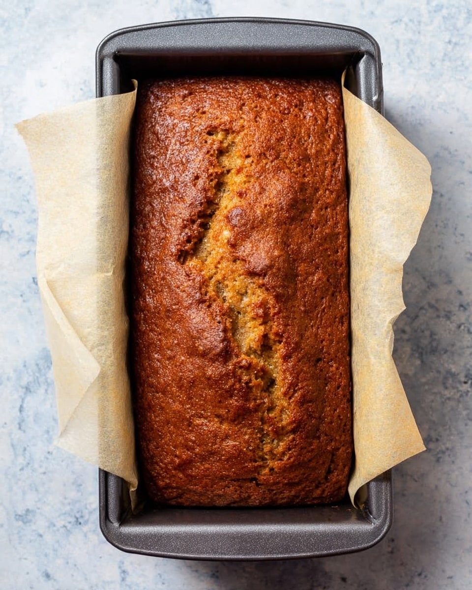 The image shows an overhead view of various baking ingredients arranged neatly on a white marbled surface. There is a large white bowl filled with flour at the top left, next to small white bowls each holding salt, vanilla, and cinnamon in order from left to right. Below these, two eggs sit side by side near a bowl of baking powder and another bowl filled with sugar placed below them. On the left center, there is a small white bowl with walnuts and next to it a white plate holding two sticks of butter. Below the butter, there is a white bowl with cubed butter. A glass measuring cup with heavy cream is placed at the bottom left next to a sifter of sugar and a small white bowl of water. At the bottom right, two ripe bananas with brown spots lie side by side. A bag of granulated sugar is partially visible at the far left edge. All items are in white containers or plates on the white marbled surface. Photo taken with an iphone --ar 4:5 --v 7