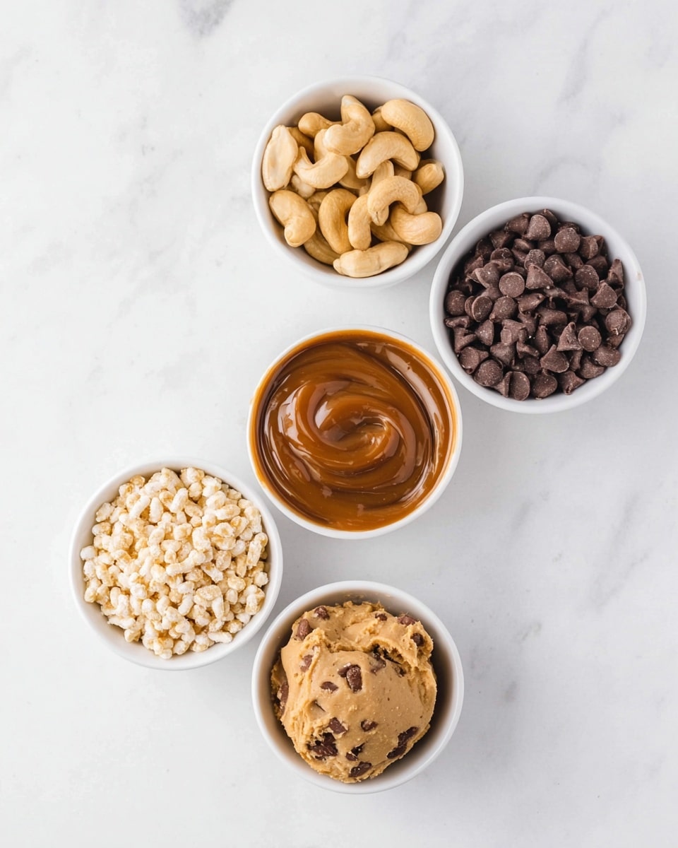 The image shows five small white bowls arranged in a circle on a white marbled surface. At the top left, a bowl holds raw cashew nuts with a light tan color and smooth curved shapes. At the top right, a bowl contains dark brown chocolate chips with a shiny texture. At the center, a bowl is filled with smooth caramel sauce with a rich, glossy brown color and some swirls on the surface. At the bottom left, a bowl holds puffed rice, which is light beige and airy with a crunchy texture. At the bottom right, a bowl contains a scoop of chocolate chip cookie dough, showing a beige base speckled with small dark brown chocolate chips. photo taken with an iphone --ar 4:5 --v 7