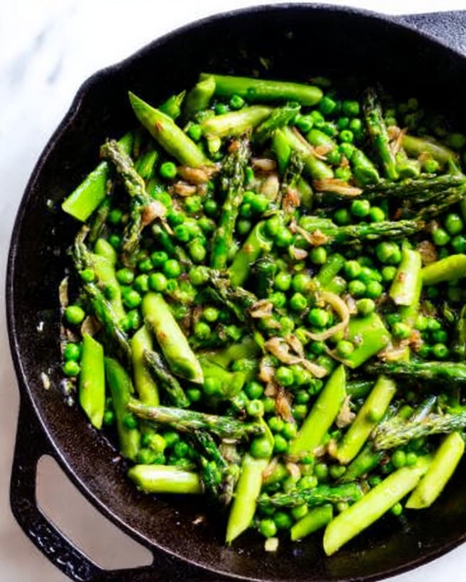 A black cast iron pan on a white marbled surface filled with bright green asparagus pieces and fresh green peas mixed together. Small bits of browned garlic and sautéed shallots are scattered evenly throughout the vegetables. The asparagus is cut into medium-length segments, and the peas are whole, creating a mix of different green shades and textures. The light highlights the fresh and cooked surfaces, giving a simple, healthy vegetable dish look. Photo taken with an iphone --ar 4:5 --v 7
