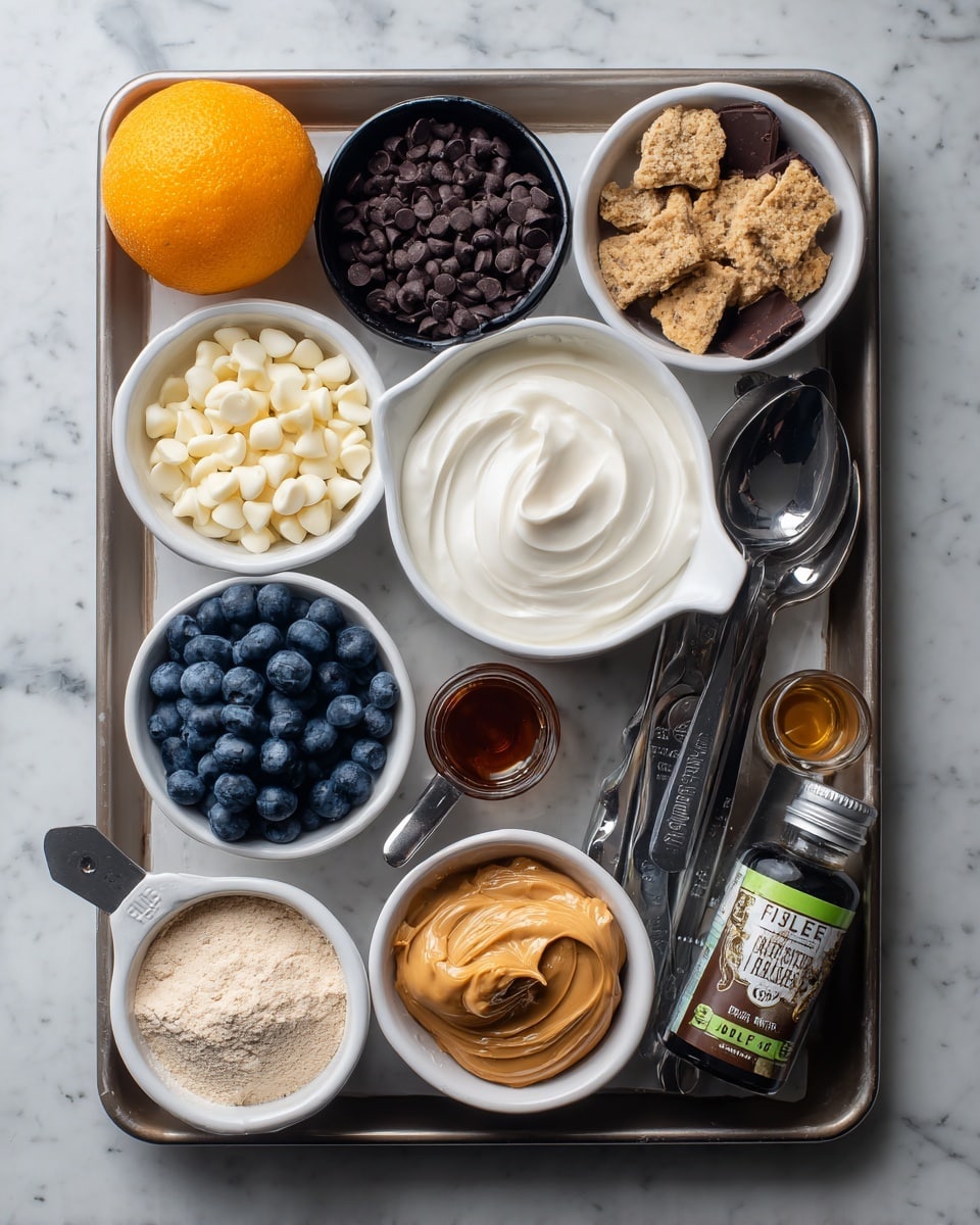 A top-down view of a baking tray with various ingredients arranged neatly. In the center, there is a white measuring cup filled with smooth, white Greek yogurt. Above it, a small black bowl holds dark chocolate chips. To the left of the bowl, a white bowl contains white chocolate chips. Below the white chocolate chips, a white bowl is filled with fresh blueberries. On the bottom left corner, a measuring cup of light brown protein powder rests, with another scoop of lighter protein powder near the top right of the tray. Next to the yogurt, on the right side, a metal measuring cup holds broken cookie pieces. Below it, a silver spoon is heaped with thick peanut butter. To the right of the peanut butter spoon is a small bottle of almond extract with a green label. A measuring spoon with dark amber maple syrup is placed near the peanut butter. In the bottom left, a tiny spoon of dark vanilla extract sits next to the blueberries. In the top left corner, a whole orange adds a bright pop of color. The tray is on a white marbled surface. photo taken with an iphone --ar 4:5 --v 7