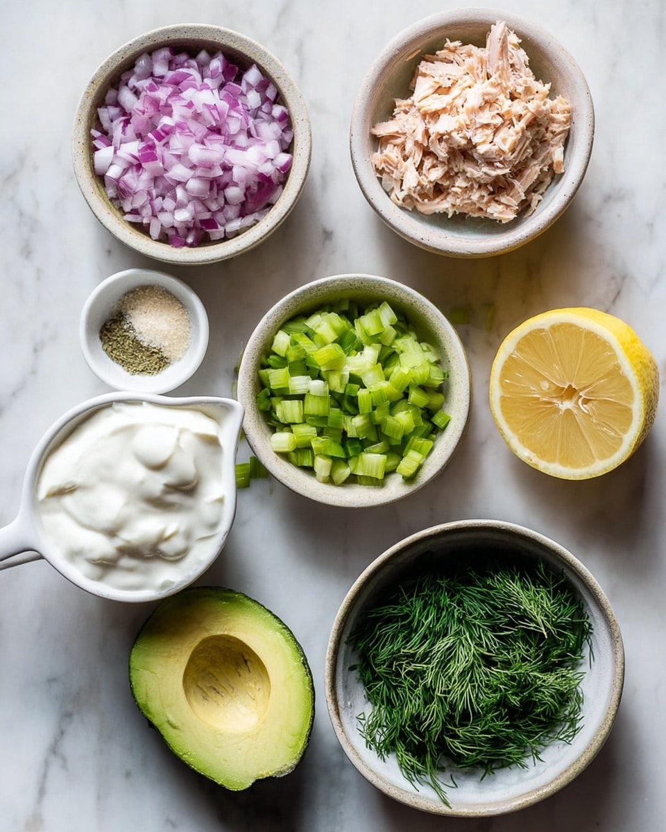 The image shows seven small white bowls arranged on a white marbled surface, each containing fresh ingredients for a dish. One bowl holds finely chopped red onion, another has small diced green celery pieces. A third bowl contains shredded light pink salmon, while a small white measuring cup has thick white yogurt. A halved avocado with bright green creamy flesh sits next to a bowl filled with finely chopped dark green fresh dill. There is also a halved lemon showing its bright yellow inside and a tiny bowl with light beige garlic powder and white salt. The bowls are arranged neatly with soft natural light highlighting the fresh textures and colors. photo taken with an iphone --ar 4:5 --v 7