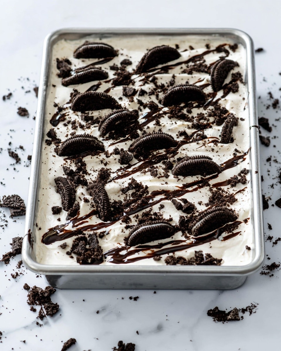 The image shows ingredients neatly placed on a white marbled surface. There are two white eggs positioned near the center, with a clear glass pitcher of milk on the right side. Below the eggs, there is a clear glass bowl filled with yellow oil. To the left, a white bag labeled