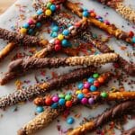 Chocolate-Covered Pretzel Sticks with Toppings and White Drizzle Recipe