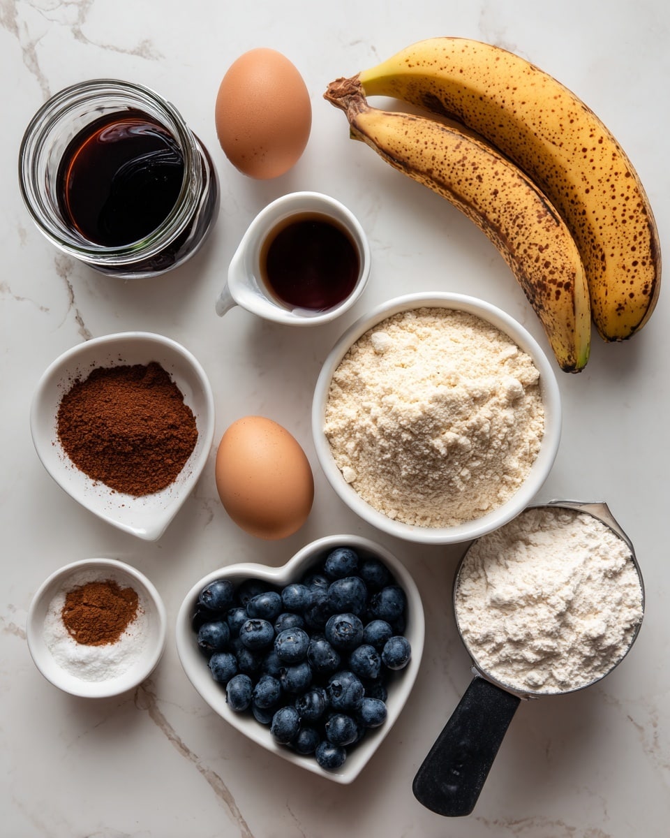 The image shows various baking ingredients placed on a white marbled surface. At the top left, there is a glass jar with dark brown vanilla extract. Below it, a small white cup holds maple syrup, dark and shiny. Next to the syrup is a single brown egg. On the right side near the top, a white bowl is filled with light beige almond flour, topped with a brown egg. Two bananas, one ripe with brown spots and one less ripe, lie next to the bowl. Below, a heart-shaped white bowl is full of deep blue blueberries. Near the bottom left, a small white dish contains brown cinnamon and white baking powder and baking soda together. Finally, a metal measuring cup with a black handle holds off-white oat flour. The items are arranged neatly with clear labels identifying each ingredient photo taken with an iphone --ar 4:5 --v 7