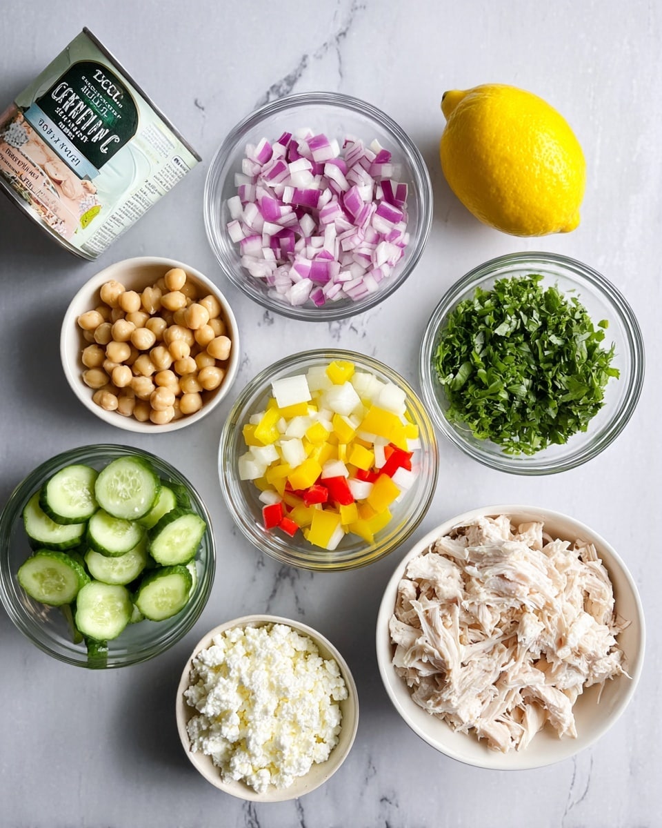 The image shows an arrangement of several small clear glass and white bowls with different chopped ingredients on a white marbled surface. There is a bowl with white, shredded chicken pieces positioned at the bottom right, and next to it on the right is a small white bowl filled with crumbled white cheese. Above that is a whole bright yellow lemon. To the left of the lemon, a clear bowl holds a mix of chopped yellow, red, and artichoke pieces, divided into three sections. Above that bowl, another clear bowl is filled with chopped fresh green herbs. To the left of this are two more bowls: one light-colored bowl with diced cucumber and one white bowl with finely chopped red onion. There is also a can of garbanzo beans near the bottom center and a container of Greek yogurt on the upper left. Photo taken with an iphone --ar 4:5 --v 7