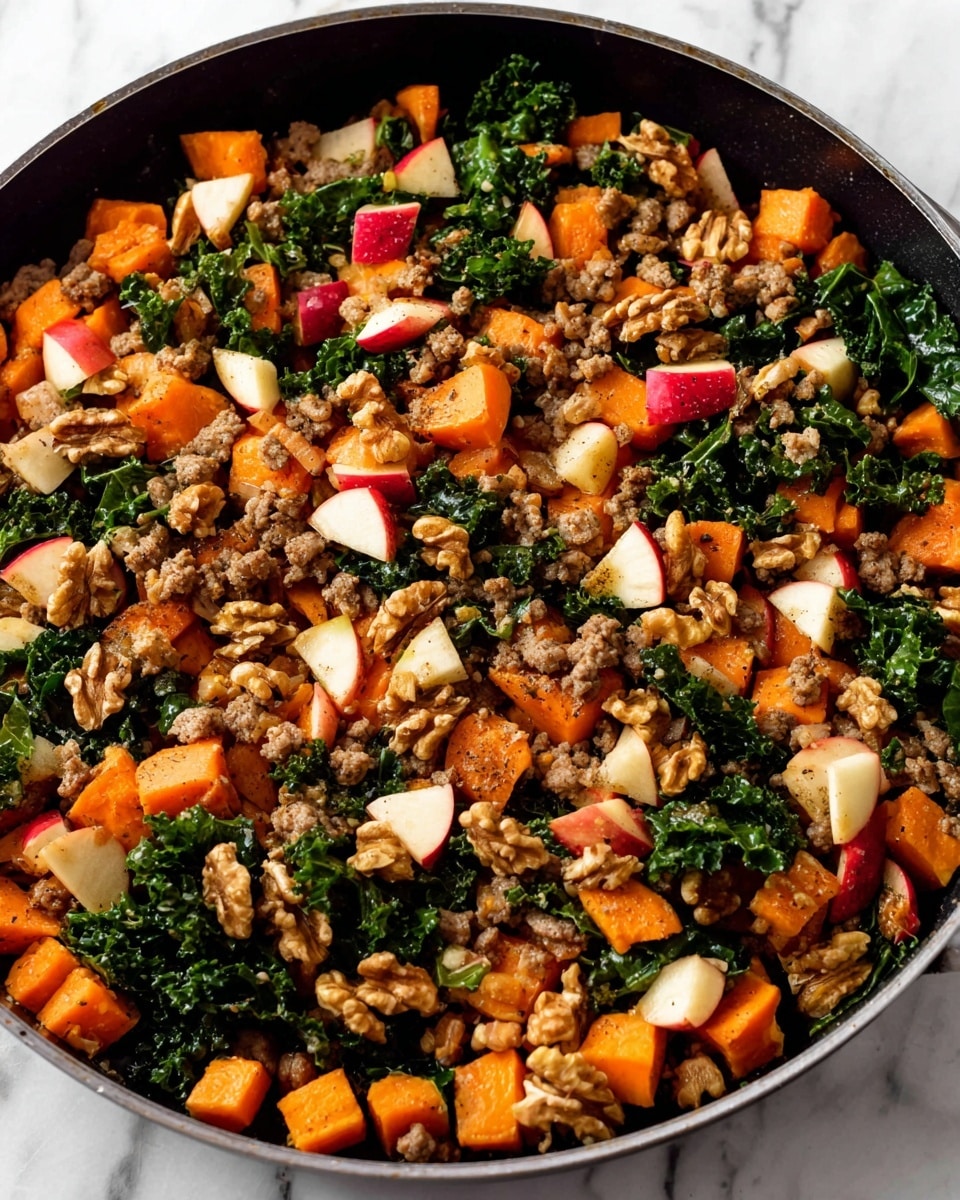 A close-up of a black pan filled with a colorful mix of ingredients, showing a first layer of chopped cooked orange sweet potatoes with a soft texture, scattered with small pieces of cooked ground meat in light brown color. Intermixed are small chunks of red and white apple pieces with smooth surfaces, and dark green leafy kale adding a fresh look. On top, halves and pieces of walnut with rough texture are spread evenly, all placed on a white marbled surface. photo taken with an iphone --ar 4:5 --v 7
