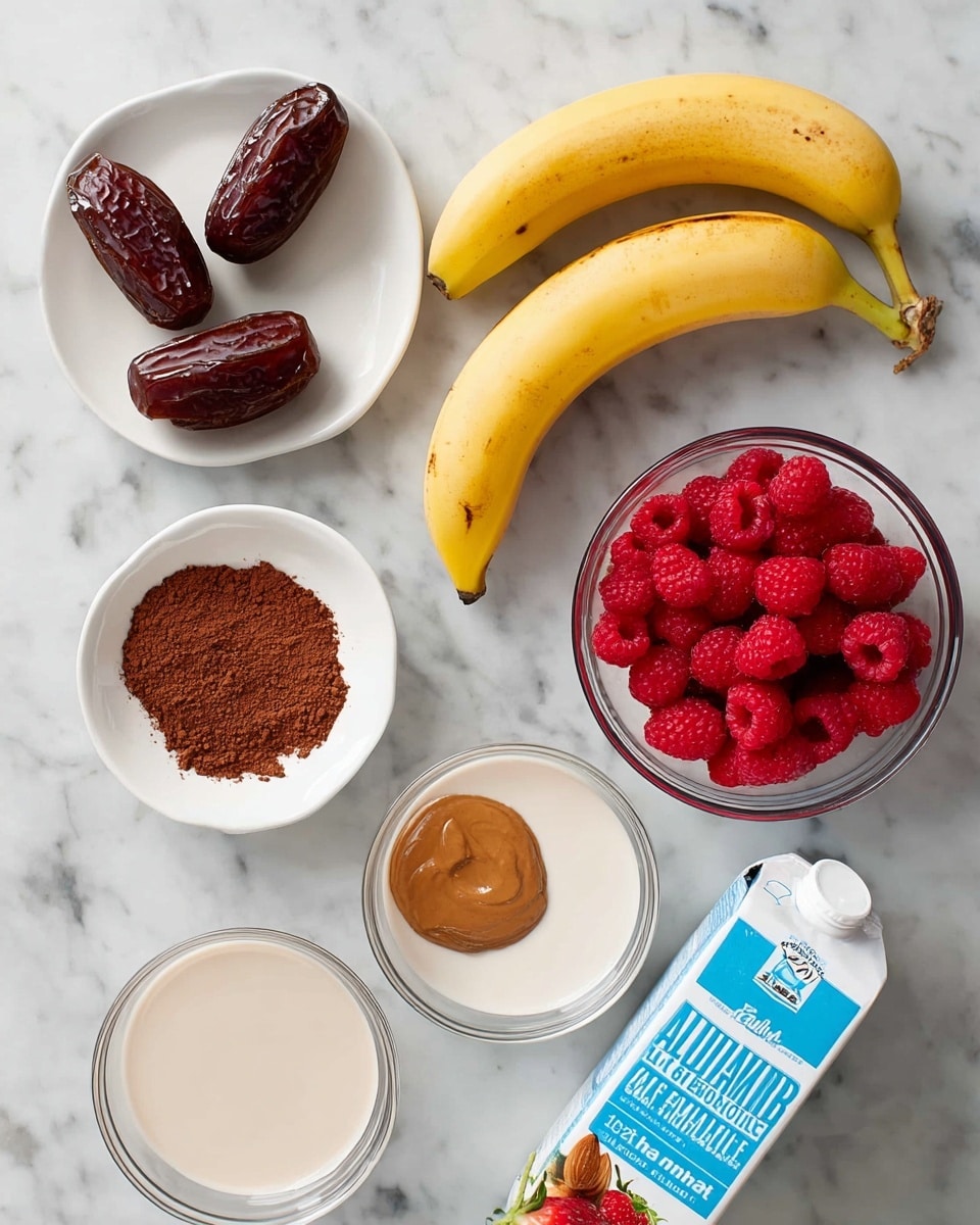 The image shows ingredients laid out on a white marbled surface: two dark brown dates at the top left, a ripe yellow banana with some brown spots in the center, a small white bowl with a smooth brown almond butter below the dates, a clear bowl filled with bright red raspberries at the top right, a clear bowl with red strawberries just below it, a small white plate with dark brown cocoa powder is placed near the banana, two clear bowls filled with light beige almond milk are at the bottom left, and a blue carton of unsweetened vanilla almond milk is positioned diagonally in the bottom right corner, creating a clean and organized setup, photo taken with an iphone --ar 4:5 --v 7