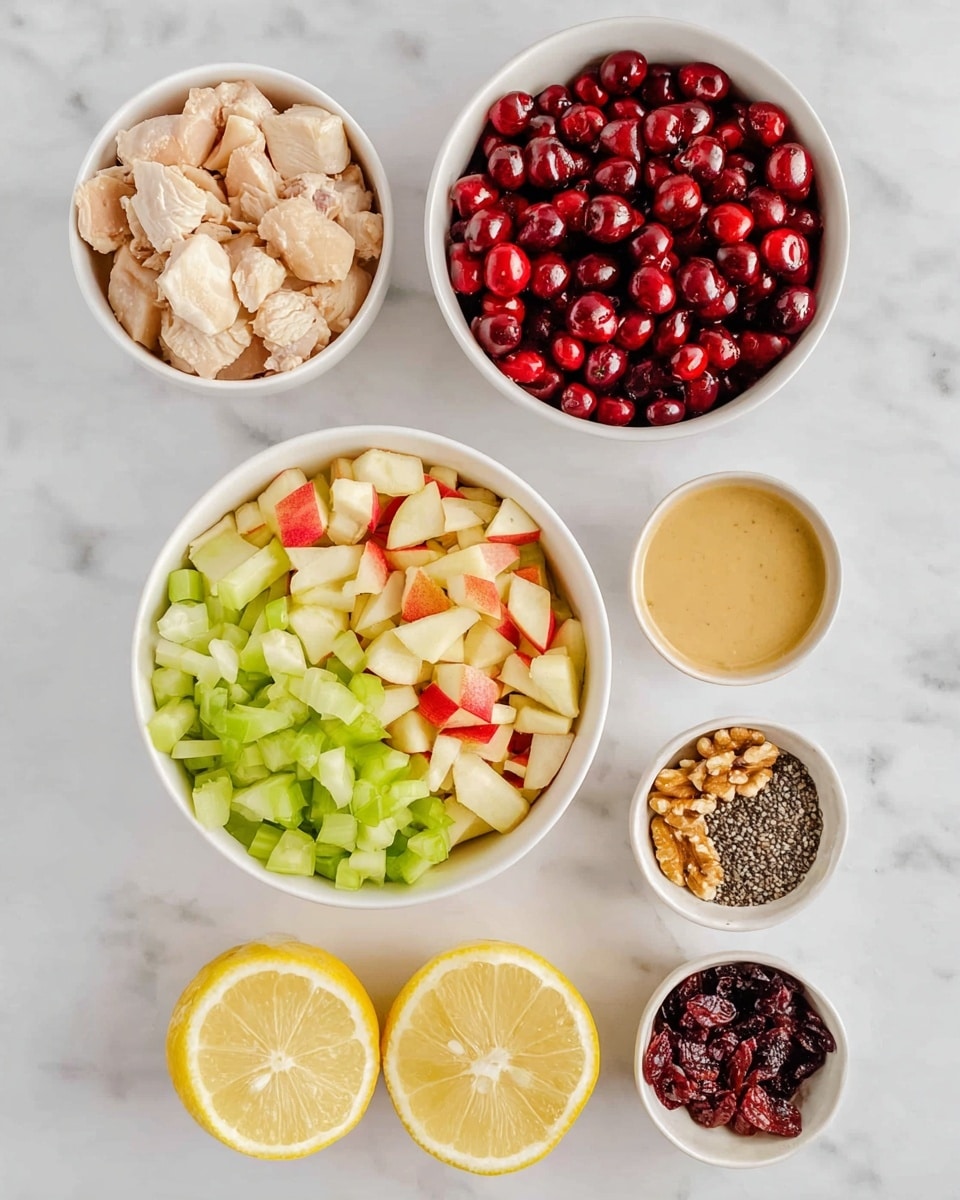 The image shows several white bowls arranged on a white marbled surface. One bowl is filled with chopped light beige cooked chicken pieces. Another larger bowl contains three neat layers: bright red halved cherries on top, a middle layer of chopped green celery, and a bottom layer of diced apple pieces with red skin and yellow flesh. Smaller white bowls hold creamy beige sauce, golden brown walnut pieces, dark red dried berries, tiny black chia seeds, and amber-colored honey or syrup. At the bottom, two lemon halves with bright yellow flesh and seeds are placed side by side. Photo taken with an iphone --ar 4:5 --v 7