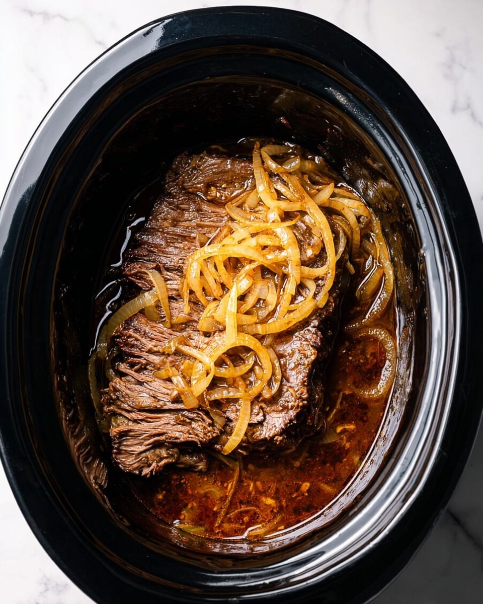 A large piece of cooked meat sits at the bottom of a black slow cooker, covered with a layer of cooked, golden-brown onions that are thinly sliced and slightly translucent. The meat has a dark brown color and smooth texture with visible juices pooling around it, creating a shiny surface. The slow cooker is on a white marbled surface, and the whole scene is brightly lit with clear details of the textures and colors. photo taken with an iphone --ar 4:5 --v 7