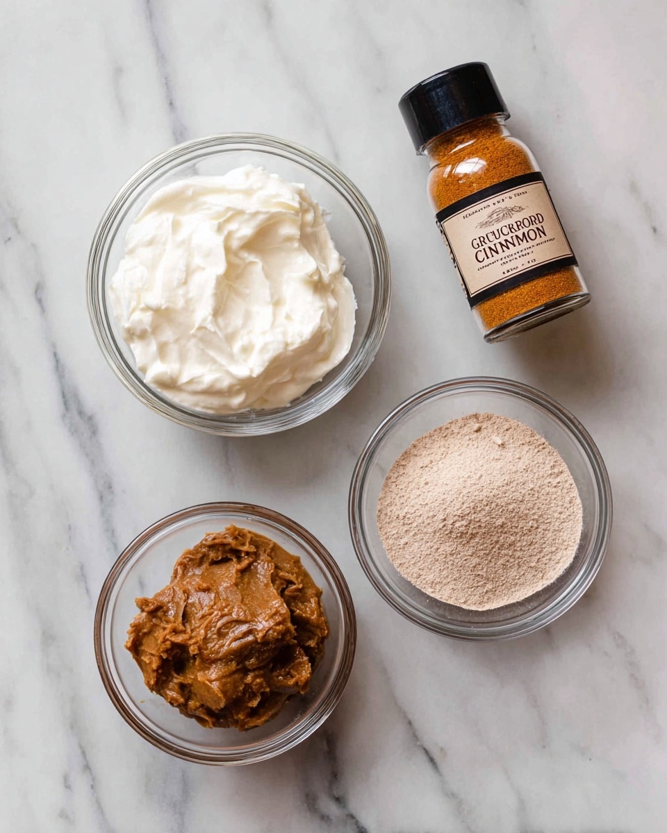 The image shows four items arranged on a white marbled surface: a small clear glass bowl filled with thick white cream, a smaller clear glass bowl containing a smooth brown paste with some small chunks, a clear glass bowl filled with a fine light brown powder, and a glass bottle labeled