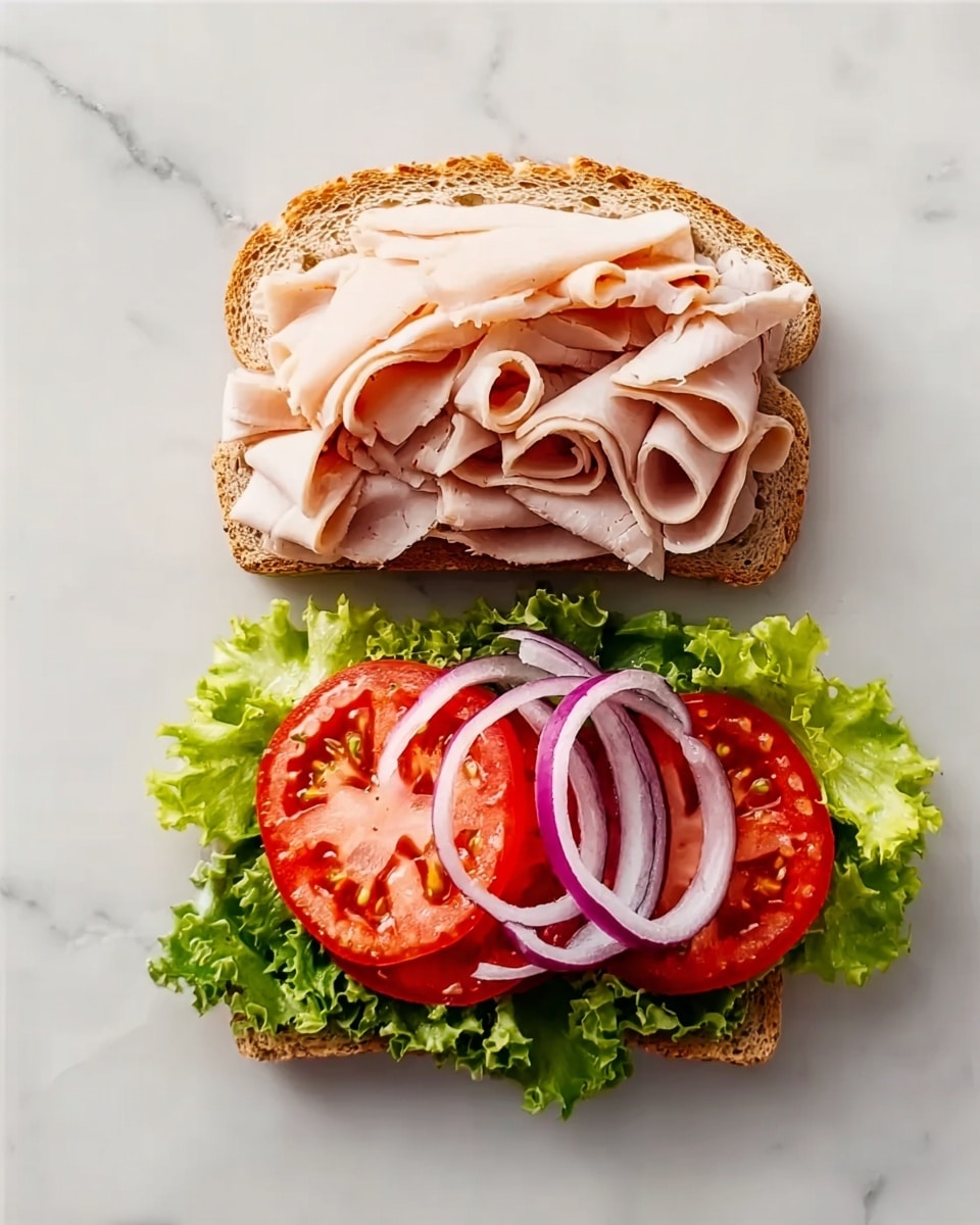 The image shows an open sandwich on a white marbled surface with two halves of light brown bread. The top half is covered with thin, pale pink slices of turkey meat, loosely piled. The bottom half has a layer of green leafy lettuce, topped with two bright red tomato slices and two rings of purple onion, resting neatly on the bread. The sandwich looks fresh and colorful with distinct layers of ingredients. Photo taken with an iphone --ar 4:5 --v 7