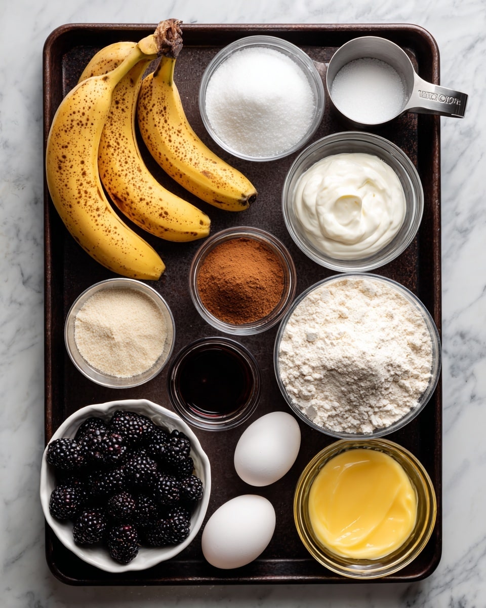 The image shows a dark rectangular baking tray with several ingredients neatly arranged on top. In the top left corner, there are three ripe yellow bananas with brown spots. Next to them is a small clear bowl filled with white sugar, while a metal measuring cup filled with thick white sour cream sits nearby. To the right, there is a larger clear bowl filled with white flour. Below that, a small clear bowl holds white baking soda and baking powder mixed with brown cinnamon and a pinch of salt. In the bottom right corner of the tray, there is a clear bowl filled with melted yellow butter. Near the bottom center, there is a small glass container with dark brown vanilla extract. Two white eggs lay to the left of the brown sugar packed tightly in a round clear bowl. Finally, in the bottom left corner, a white bowl lined with paper holds a pile of fresh blackberries. The tray is set on a white marbled surface. Photo taken with an iphone --ar 4:5 --v 7