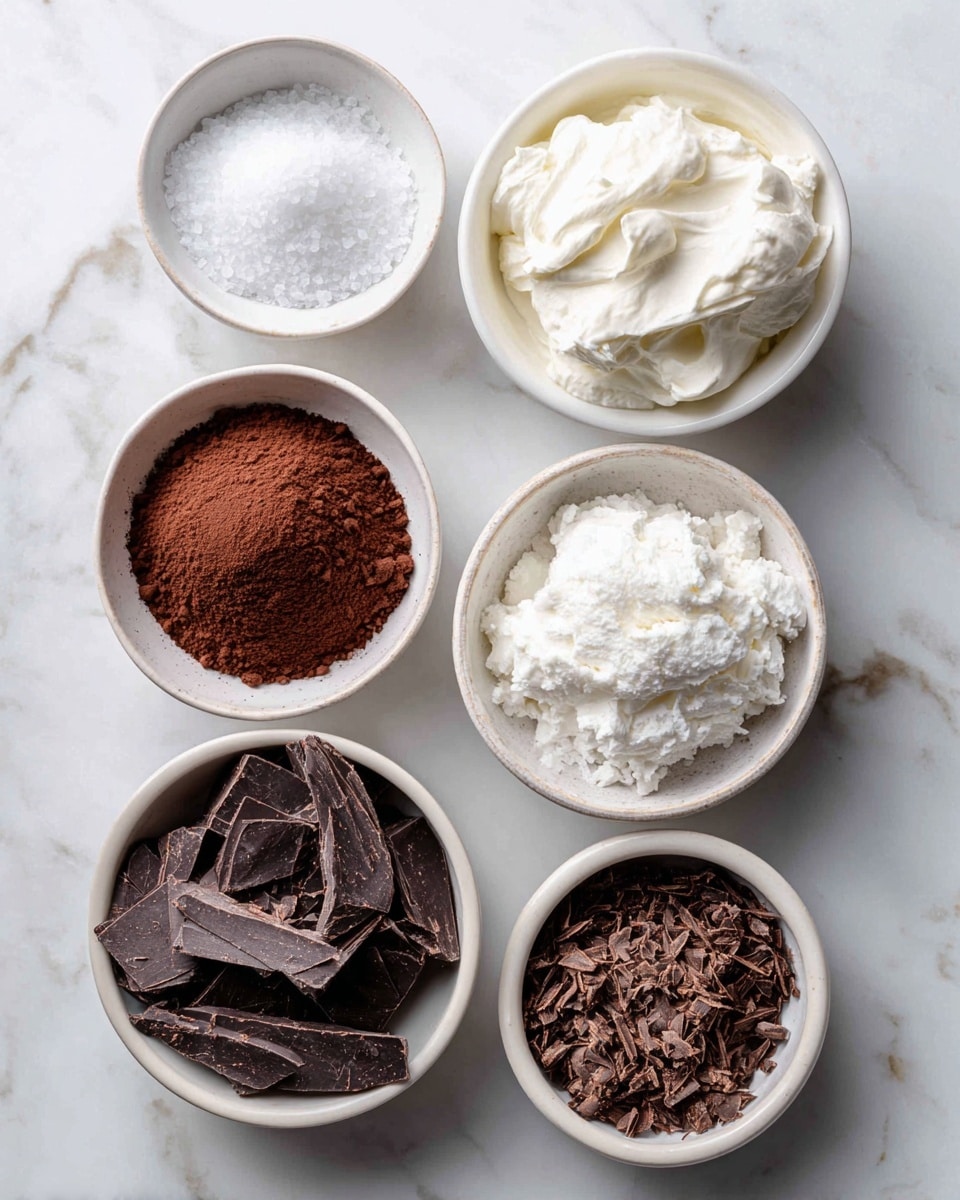 The image shows six small white bowls arranged on a white marbled surface. Each bowl contains a different ingredient: the top left bowl has fine white salt with a smooth texture, next to it on the top right is a bowl filled with full fat coconut cream, thick and white with a creamy texture. To the right of the coconut cream is a bowl full of white confectioners sweetener with a powdery look. In the middle center bowl is unsweetened cocoa powder, dark brown and crumbly. On the bottom left, a bowl is filled with dark brown 70% shaved chocolate pieces, flat and uneven. The bottom right bowl contains finer dark chocolate shavings, rough and thin. Photo taken with an iphone --ar 4:5 --v 7