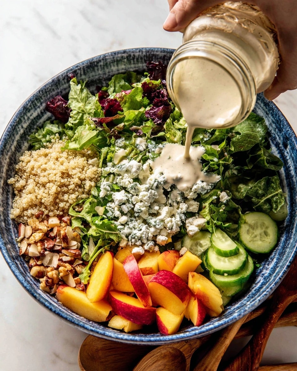 A large white bowl with blue marble edges holds a fresh salad made of multiple layers: the bottom layer is mixed green leaves with different textures, like curly kale and spinach, spread evenly; scattered on top are small grains of light beige quinoa adding a grainy texture; bright yellow and orange peach chunks provide spots of color throughout; fresh cucumber slices with a shiny green skin are mixed in; dollops of white soft cheese are placed randomly across the salad; fresh green mint and basil leaves are scattered on top; two wooden salad spoons rest inside the bowl on the right side; the bowl is placed on a light grey cloth over a white marbled surface photo taken with an iphone --ar 4:5 --v 7