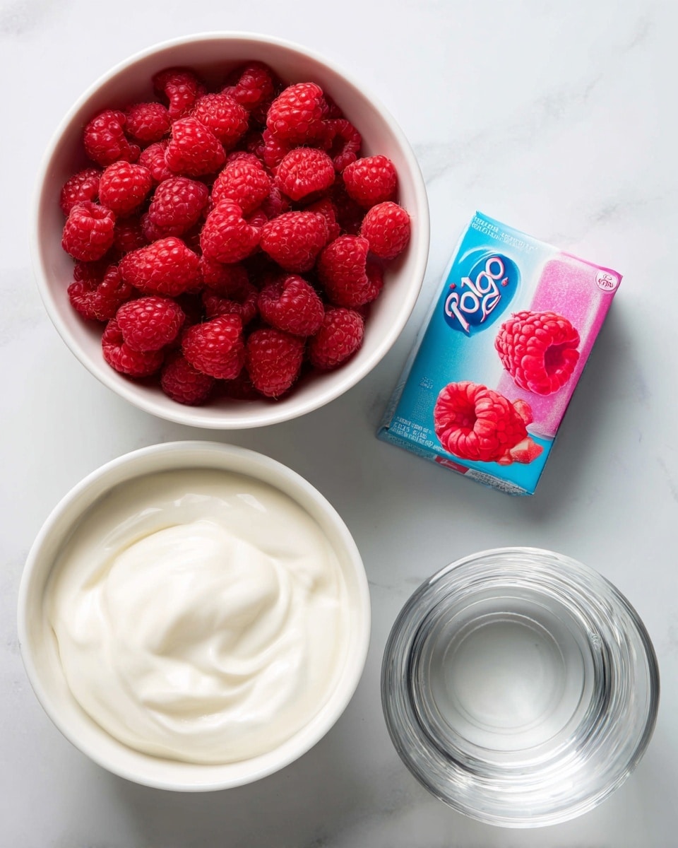 A white bowl filled with bright red raspberries sits at the top left, showing their bumpy texture clearly. Below it is another white bowl filled with smooth, creamy white yogurt, its surface soft and swirled. To the right of the raspberries is a small rectangular box of Jell-O raspberry gelatin dessert in bright blue and pink colors with a raspberry image on it. Below this box is a clear glass measuring cup containing clear water, placed on a white marbled surface that creates a clean, light background. photo taken with an iphone --ar 4:5 --v 7