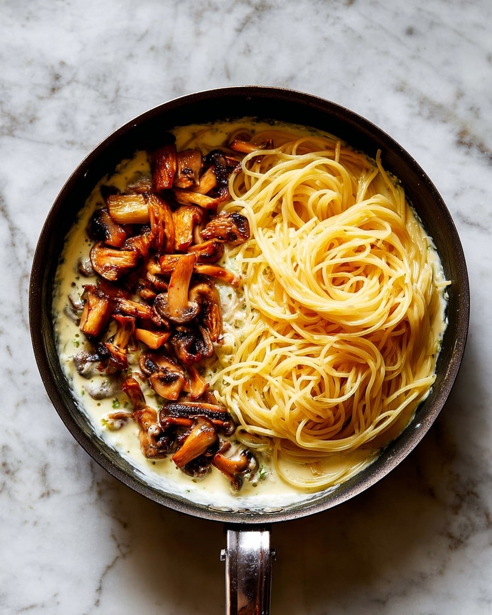A black pan sits on a white marbled surface, filled with three main layers. At the bottom, there is a creamy white sauce spreading across the base of the pan. On the left side, golden-brown cooked mushroom pieces with a slightly charred texture are scattered over the sauce. On the right side, a nest of pale yellow cooked spaghetti noodles is neatly placed, showing smooth and slightly shiny strands, sitting on top of the sauce without mixing with the mushrooms. Photo taken with an iphone --ar 4:5 --v 7