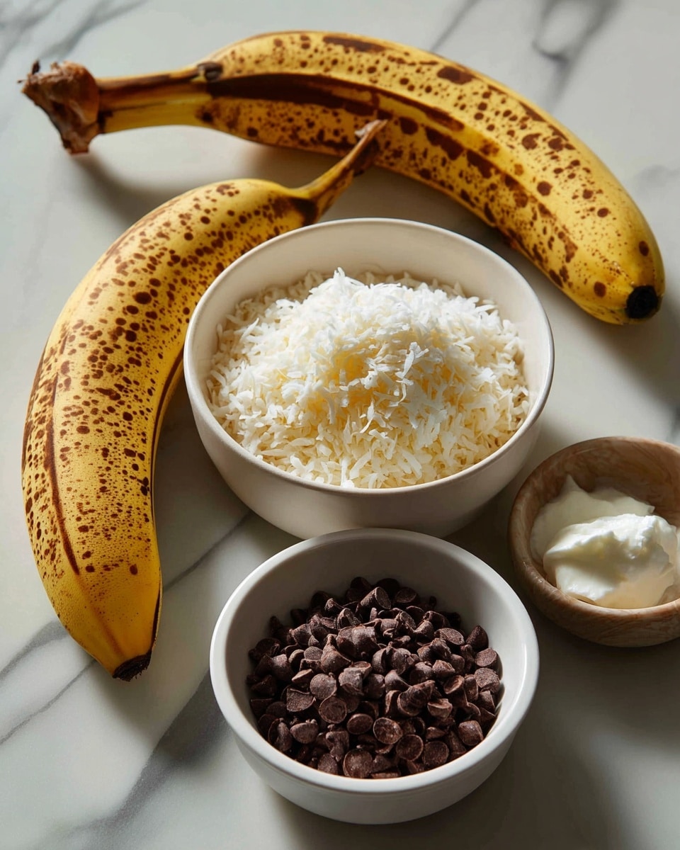 A ripe banana with brown spots lies on a white marbled surface on the left, next to three white bowls arranged in a triangle on the right side. The top bowl is filled with fine, light-colored shredded coconut, the bottom bowl holds dark brown chocolate chips, and the small bowl on the upper right contains a dollop of white coconut oil. Each ingredient has a clear label in black text on white rectangular backgrounds placed over them. Photo taken with an iphone --ar 4:5 --v 7