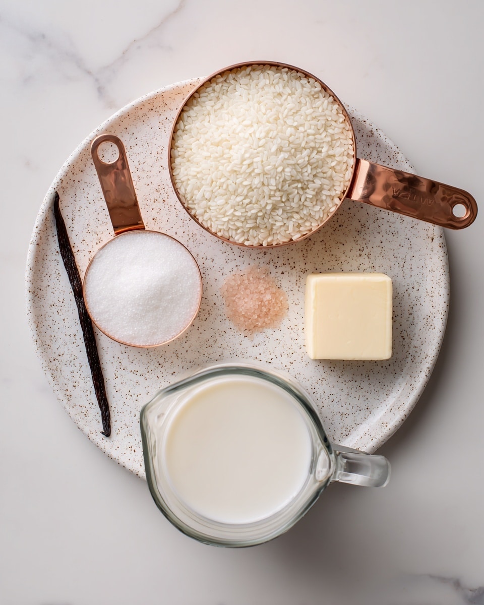 The image shows ingredients arranged neatly on a white speckled plate and a clear glass measuring cup on a white marbled surface. On the plate, there are two copper measuring cups placed near the top edge, the larger one filled with white round, short-grain Arborio rice, and the smaller one filled with white sugar. Below them on the plate are a small vanilla bean pod to the left, a small light pink salt pile in the center, and a small square of pale yellow butter on the right. Below the plate, a clear glass measuring cup is filled nearly to the top with white milk. Each ingredient is labeled with simple black arrows pointing to them. Photo taken with an iphone --ar 4:5 --v 7