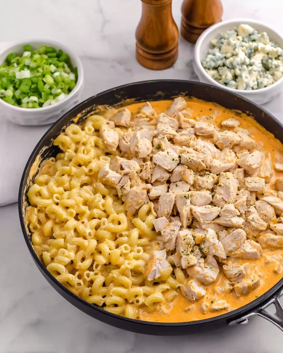 A black pan filled with three layers: the bottom layer is a creamy orange sauce, the middle layer is yellow macaroni pasta covering half of the sauce, and the top layer is chopped cooked chicken scattered over the macaroni. In the background, there are two white small bowls, one with chopped green onions and the other with crumbled blue cheese, both placed on a white marbled surface. There are also two wooden salt and pepper shakers nearby. photo taken with an iphone --ar 4:5 --v 7