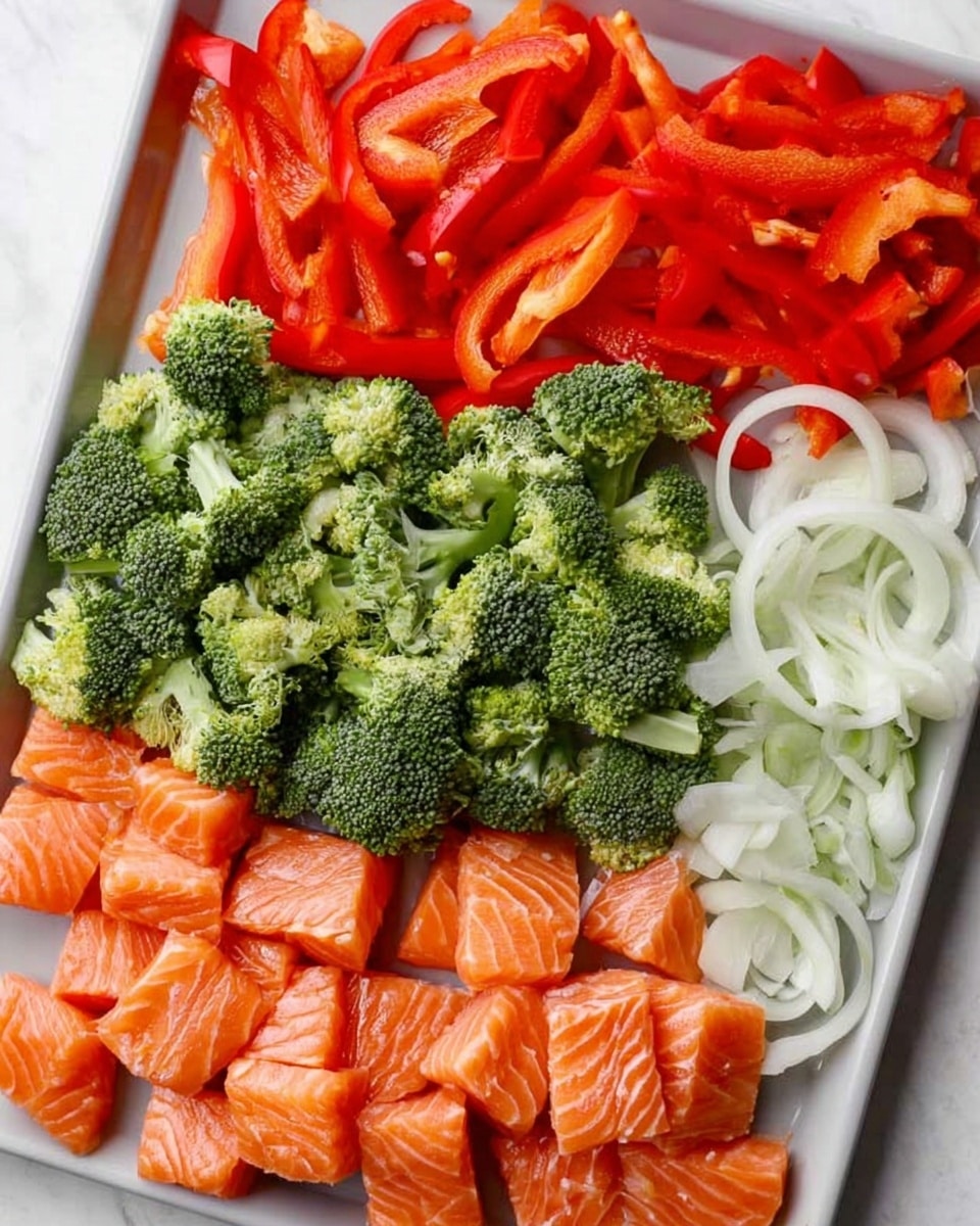 A white tray on a white marbled surface holds four separate layers of fresh ingredients arranged side by side: at the bottom left are small, evenly cubed pieces of bright orange salmon with white marbling; above the salmon is a large heap of green broccoli florets with coarse, tree-like textures; next to the broccoli are thin, long slices of red bell pepper, vibrant and slightly shiny; finally, at the top right are thin rings of white onion with smooth and slightly translucent layers. The tray displays a mix of bold colors and textures, showing freshness and variety. Photo taken with an iphone --ar 4:5 --v 7
