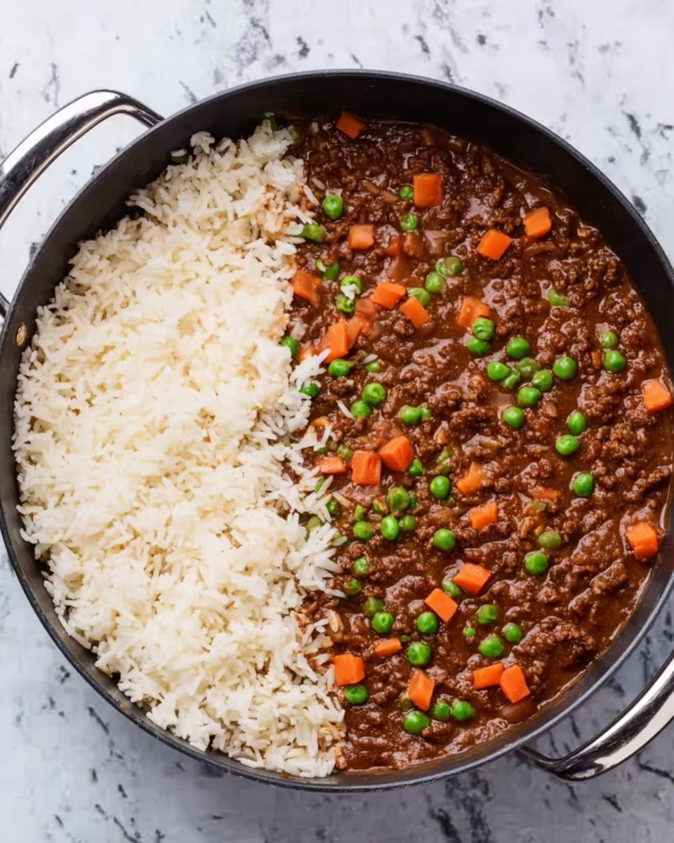The image shows a black pan filled halfway with brown minced meat sauce mixed with small pieces of carrots and green peas. On top of the sauce, on the right side, there is a pile of white cooked rice. The pan has two handles at the top edges. The background is a white marbled surface. Photo taken with an iphone --ar 4:5 --v 7