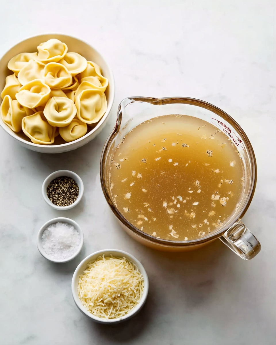 A clear glass measuring cup filled with light brown broth with small bits floating inside sits on a white marbled surface. To the left, a small white bowl holds uncooked tortellini with a pale yellow color and folded shape. In front of the measuring cup, three small white bowls hold different ingredients: one with coarse white salt, one with black pepper, and one with grated pale yellow cheese. The arrangement is neat and evenly spaced. photo taken with an iphone --ar 4:5 --v 7