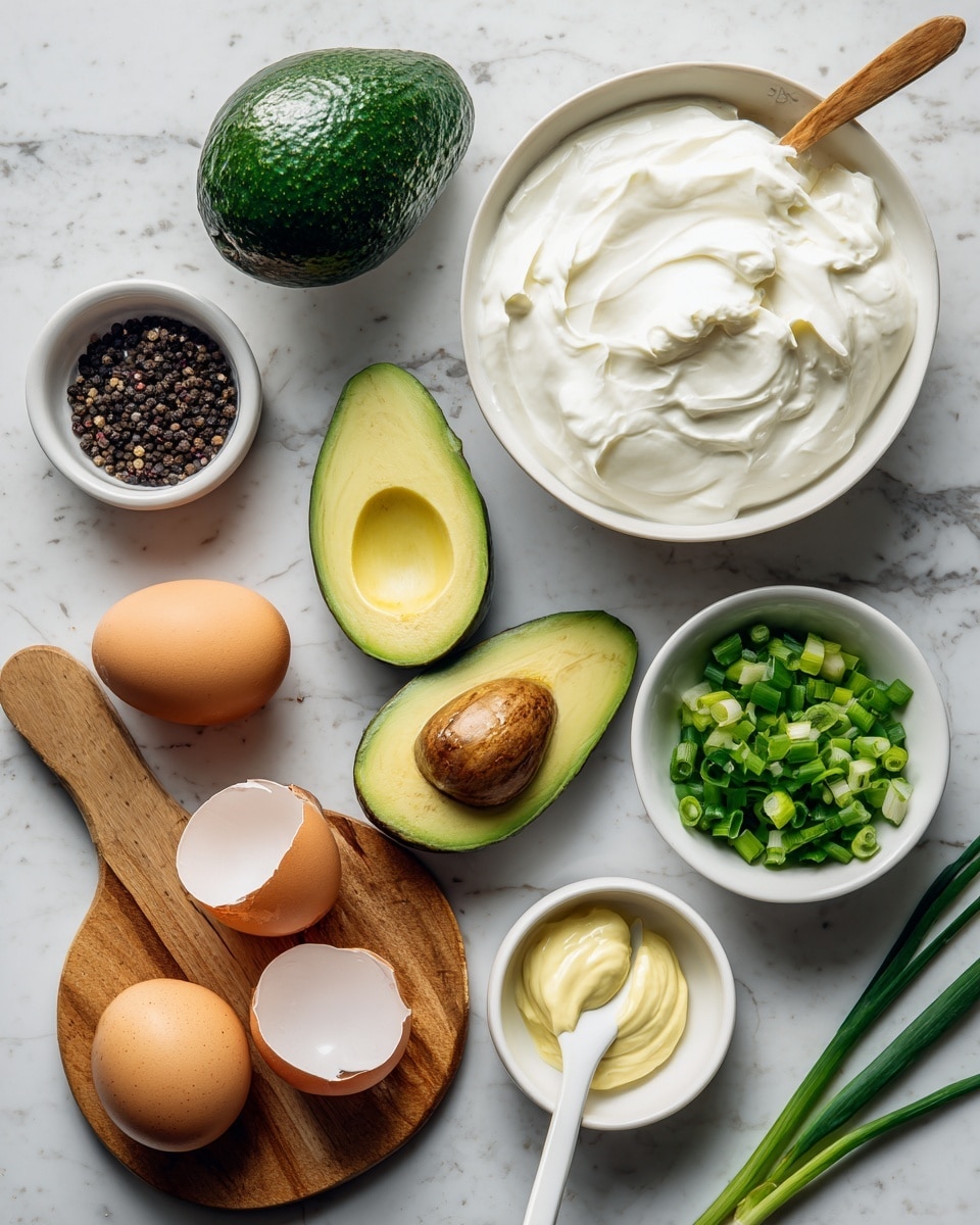 A white bowl filled with a creamy, light green mixture of mashed avocado with visible small chunks, topped with pieces of boiled egg white and yellow yolk, finely chopped green onions, and a sprinkle of black pepper. A wooden spoon is placed inside the bowl on the left side. Behind the bowl, there is a wooden board holding sliced boiled egg and a halved avocado with green flesh and a brown seed, along with a dark-handled knife. To the upper left, two slices of brown bread are lying on a white marbled surface. The whole scene is set on a white marbled texture with soft, natural lighting. photo taken with an iphone --ar 4:5 --v 7